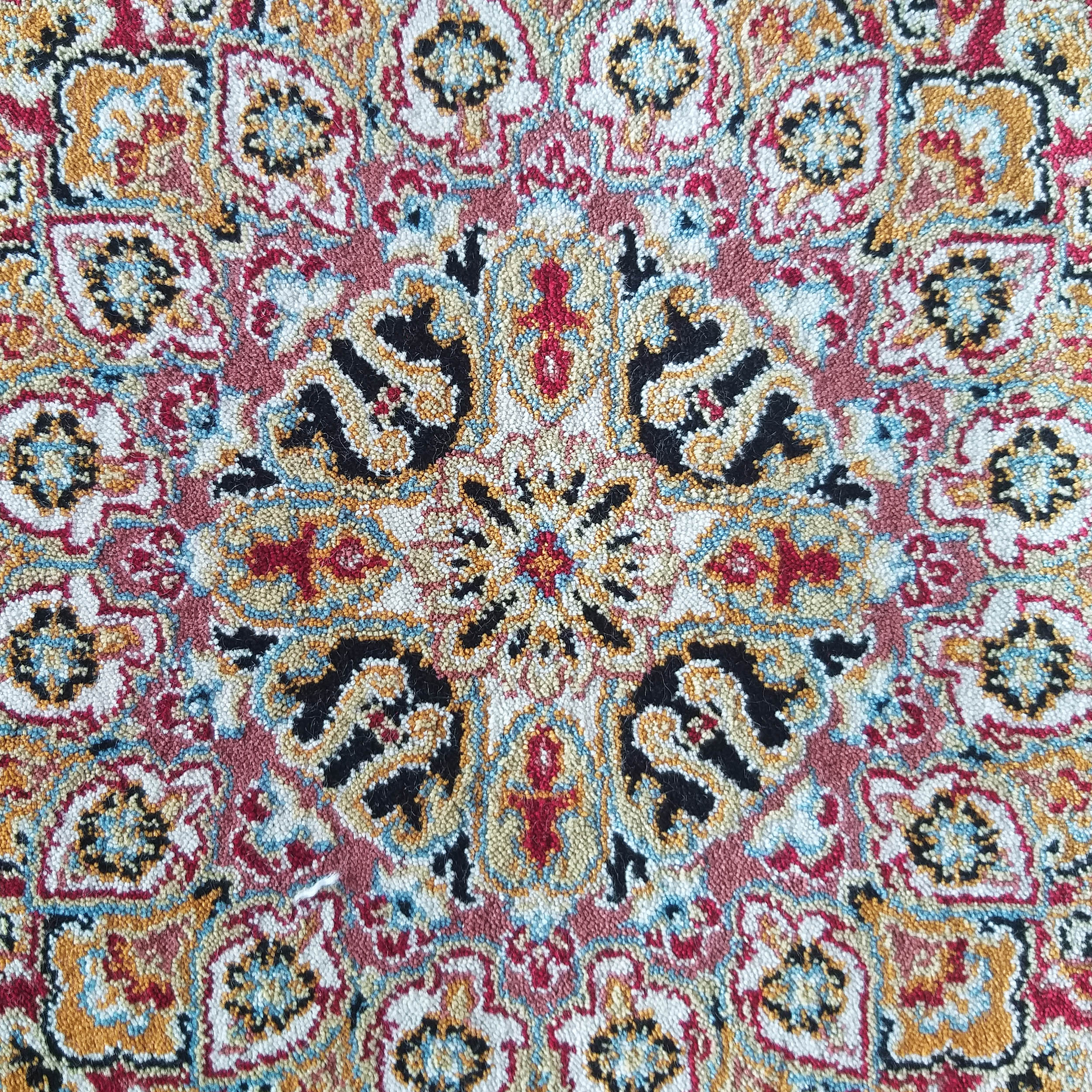 Tapis texturé aux motifs orientaux complexes et colorés en rouge, or, noir, bleu clair et crème