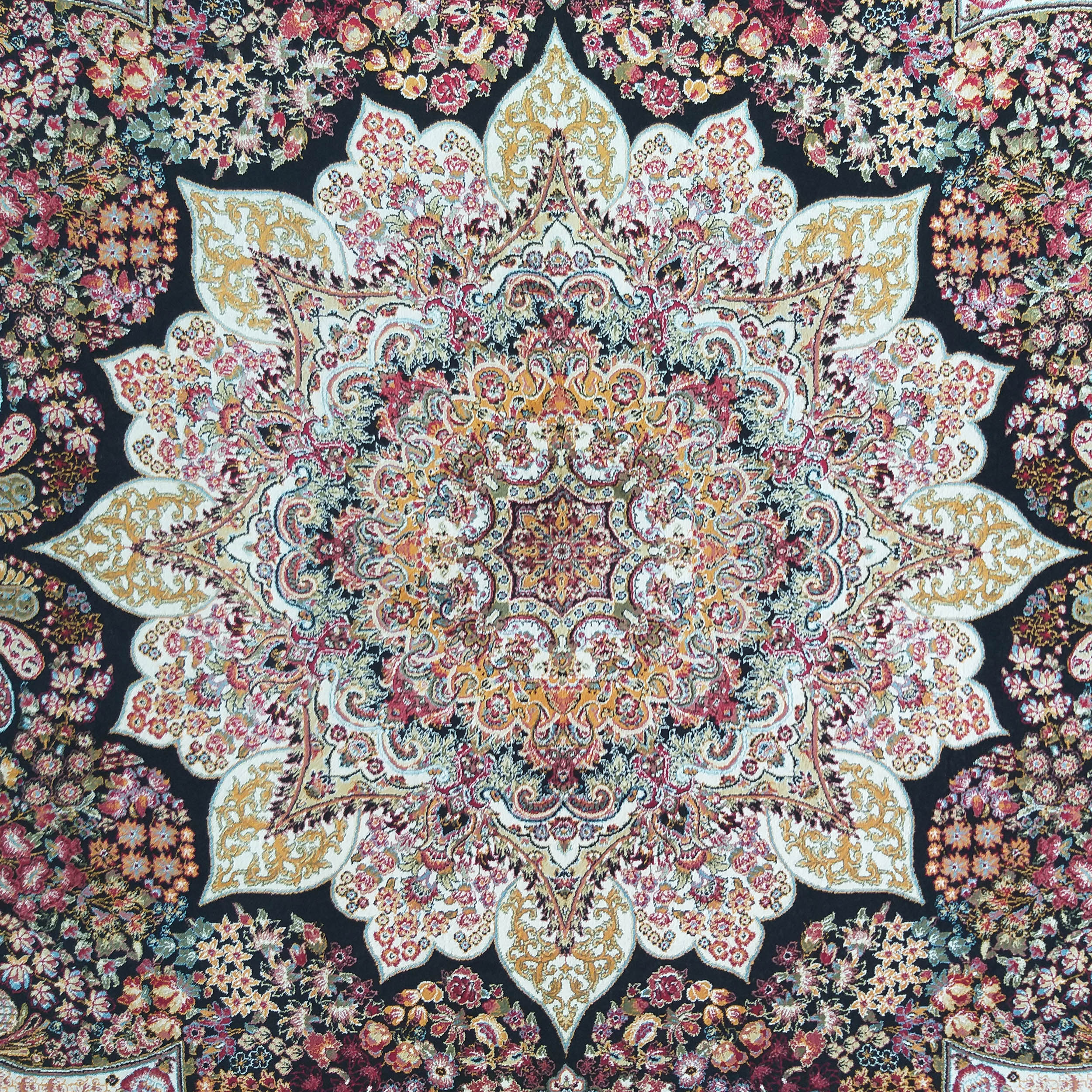 Tapis orné avec un grand médaillon floral central blanc crème, sur un fond noir avec des motifs floraux rouges, oranges, verts et bleus