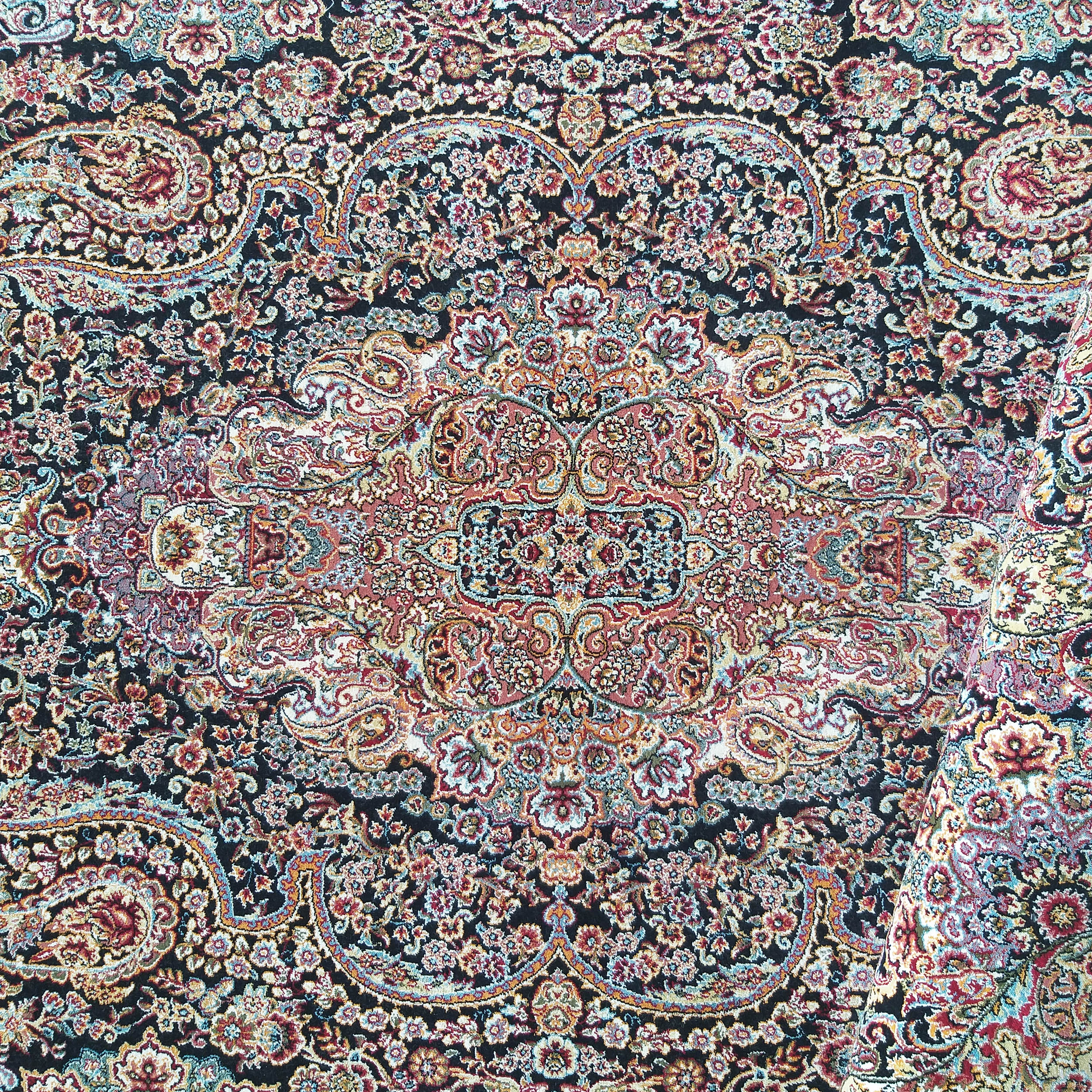 Tapis en textile sombre orné de motifs floraux et cachemire complexes, aux couleurs rouge, or, bleu et crème