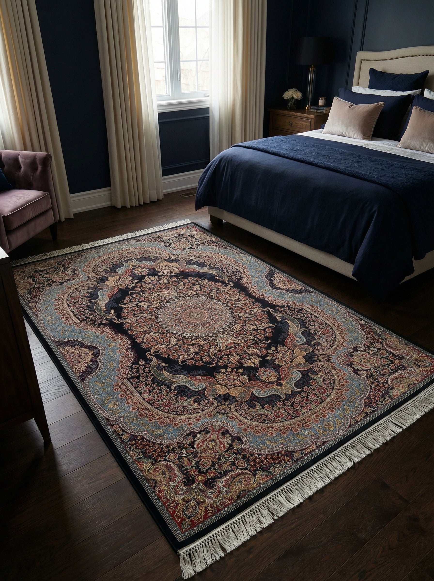 Tapis persan rectangulaire bleu marine à motifs floraux complexes rouges, dorés et bleus clairs, avec franges, dans une chambre sombre et élégante