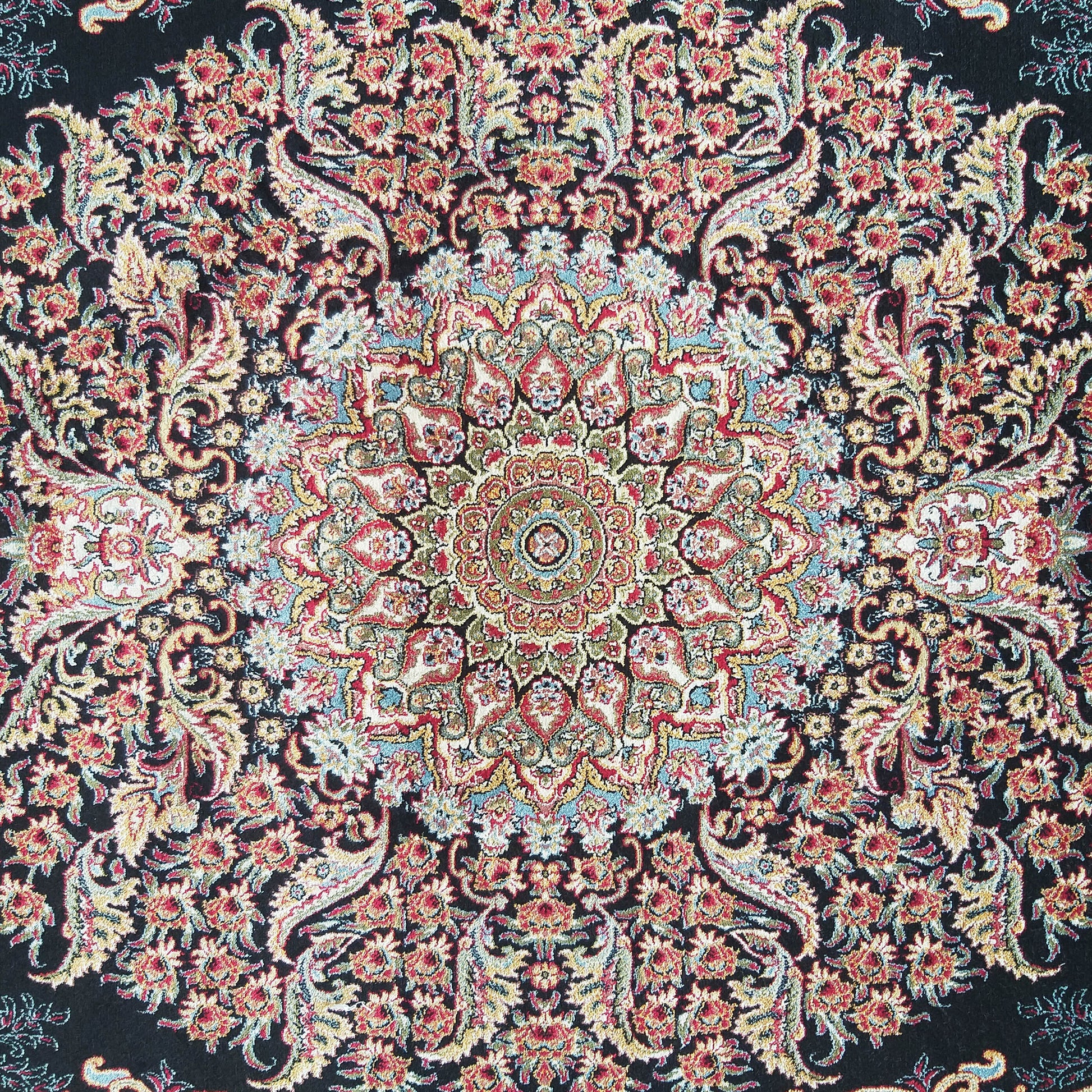 Tapis floral très détaillé et symétrique, centré sur un médaillon, aux couleurs vives rouge, or, vert et bleu ciel sur fond noir