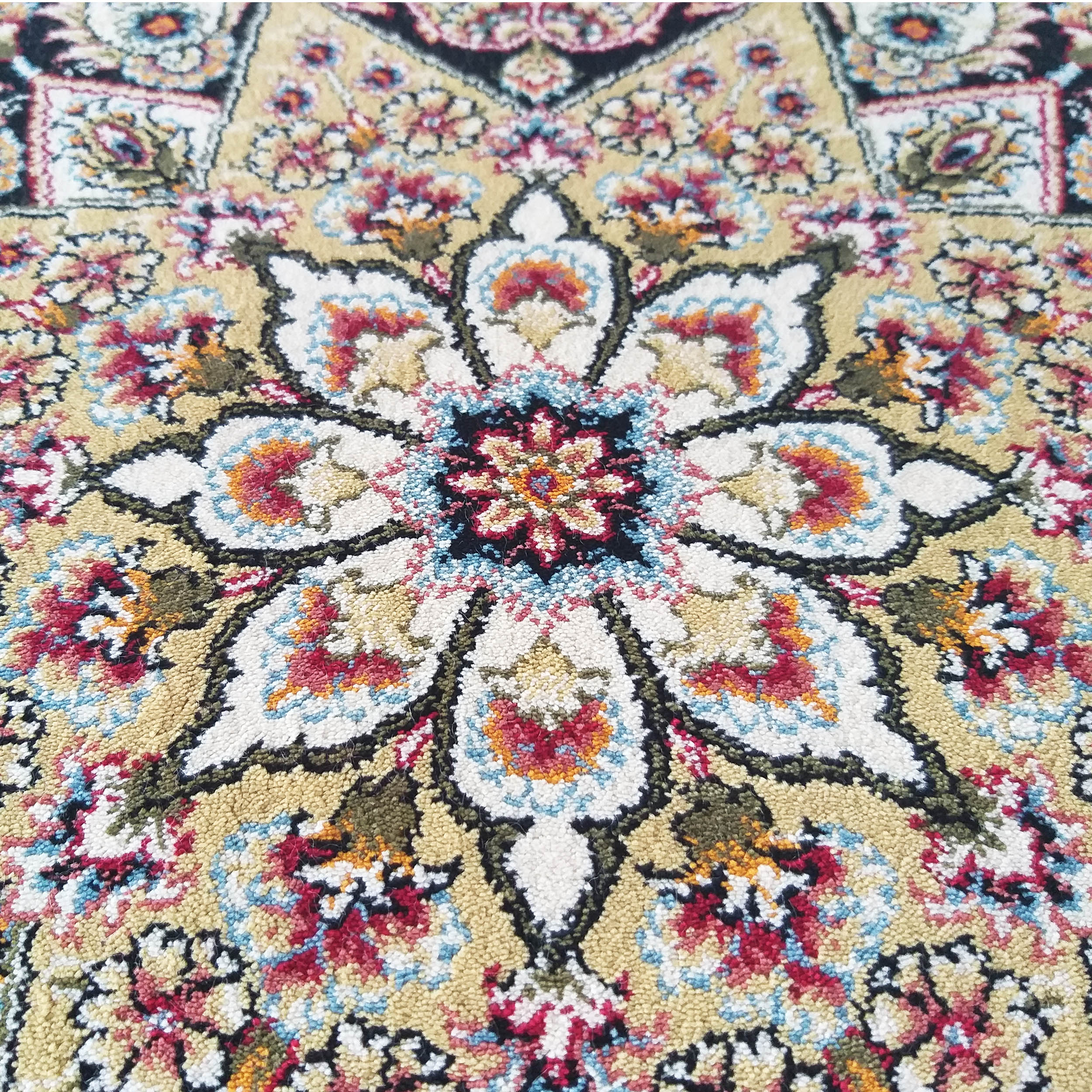Tapis à motifs floraux et arabesques sur fond jaune clair, avec des détails rouges, bleus, blancs, noirs, verts et orange