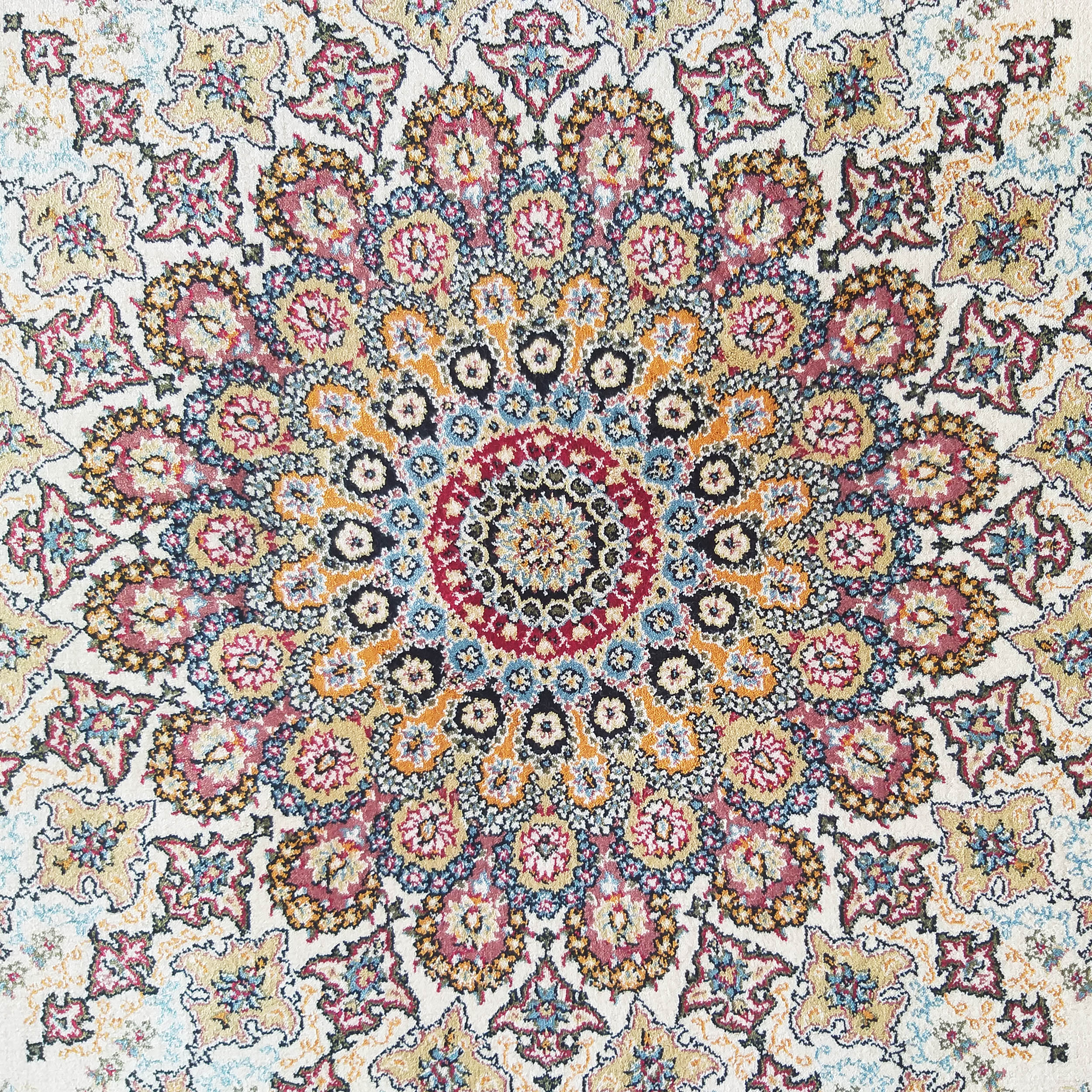 Tapis finement tissé avec un grand médaillon central et des motifs floraux complexes. Couleurs vives : crème, rouge, bleu, or, noir