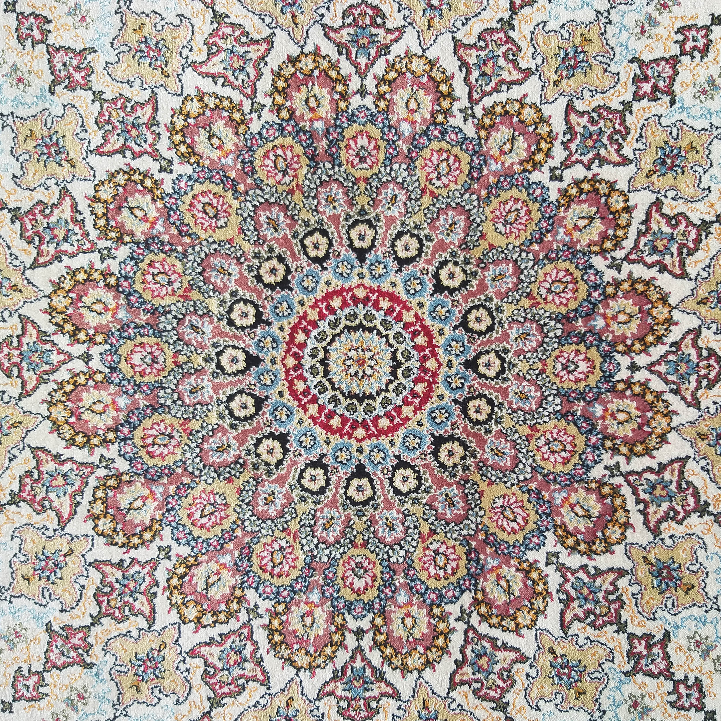 Tapis moelleux à motif floral et médaillon, couleurs rouge, or, bleu, rose et noir sur fond crème