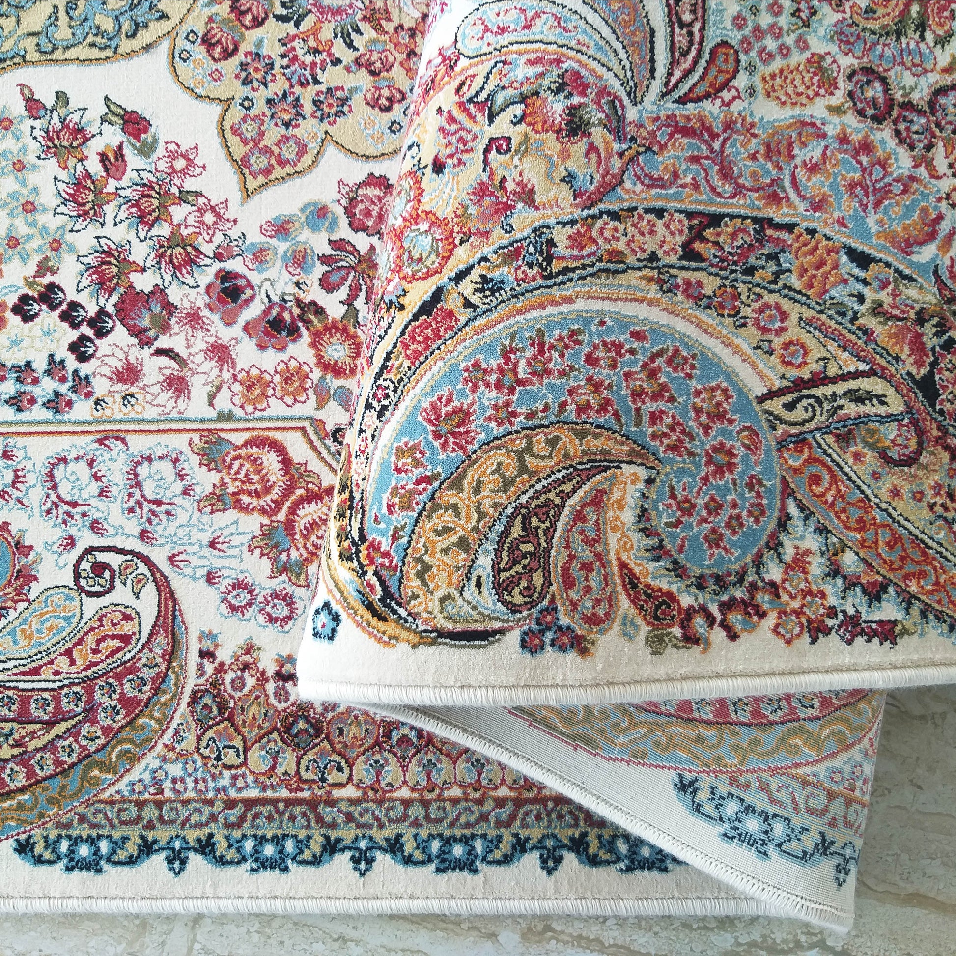 Tapis moelleux crème à motifs floraux et cachemire complexes en rouge, bleu, orange et or, partiellement roulé