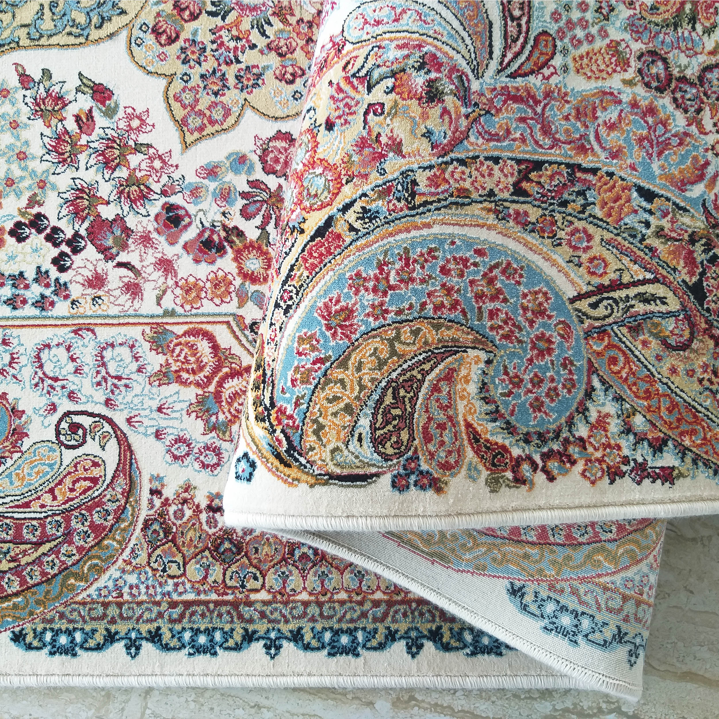 Tapis moelleux crème à motifs floraux et cachemire complexes en rouge, bleu, orange et or, partiellement roulé