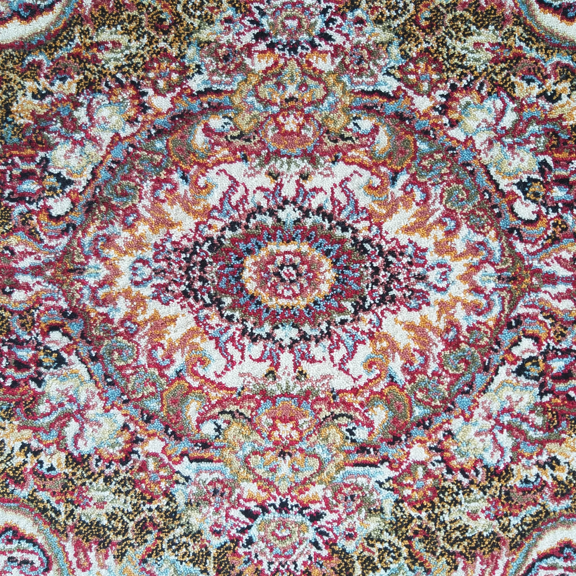 Tapis coloré à poils bouclés avec un motif central ornemental en rouge, crème, bleu, doré et noir