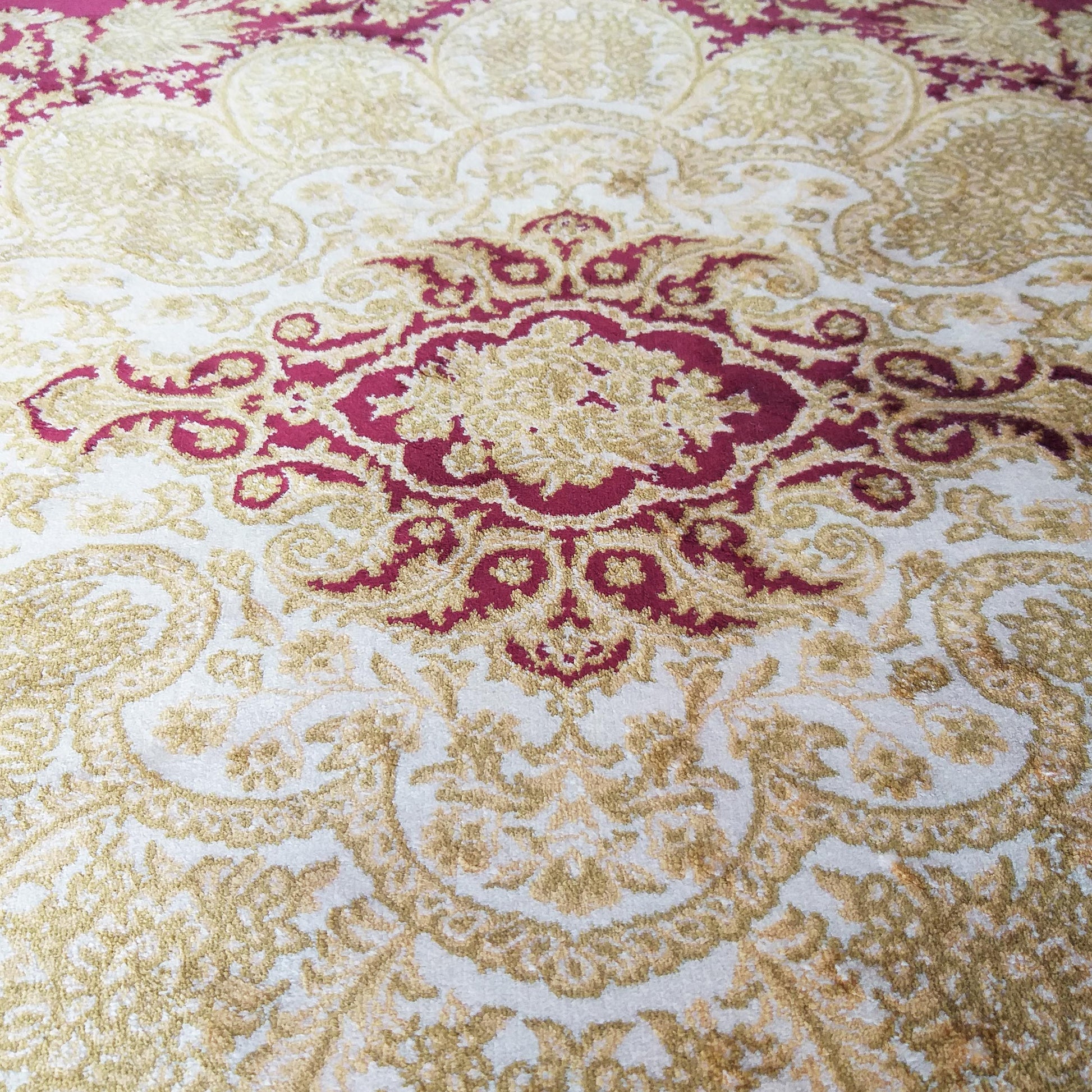 Tapis crème texturé avec de riches motifs floraux et ornementaux dorés et rouges vifs