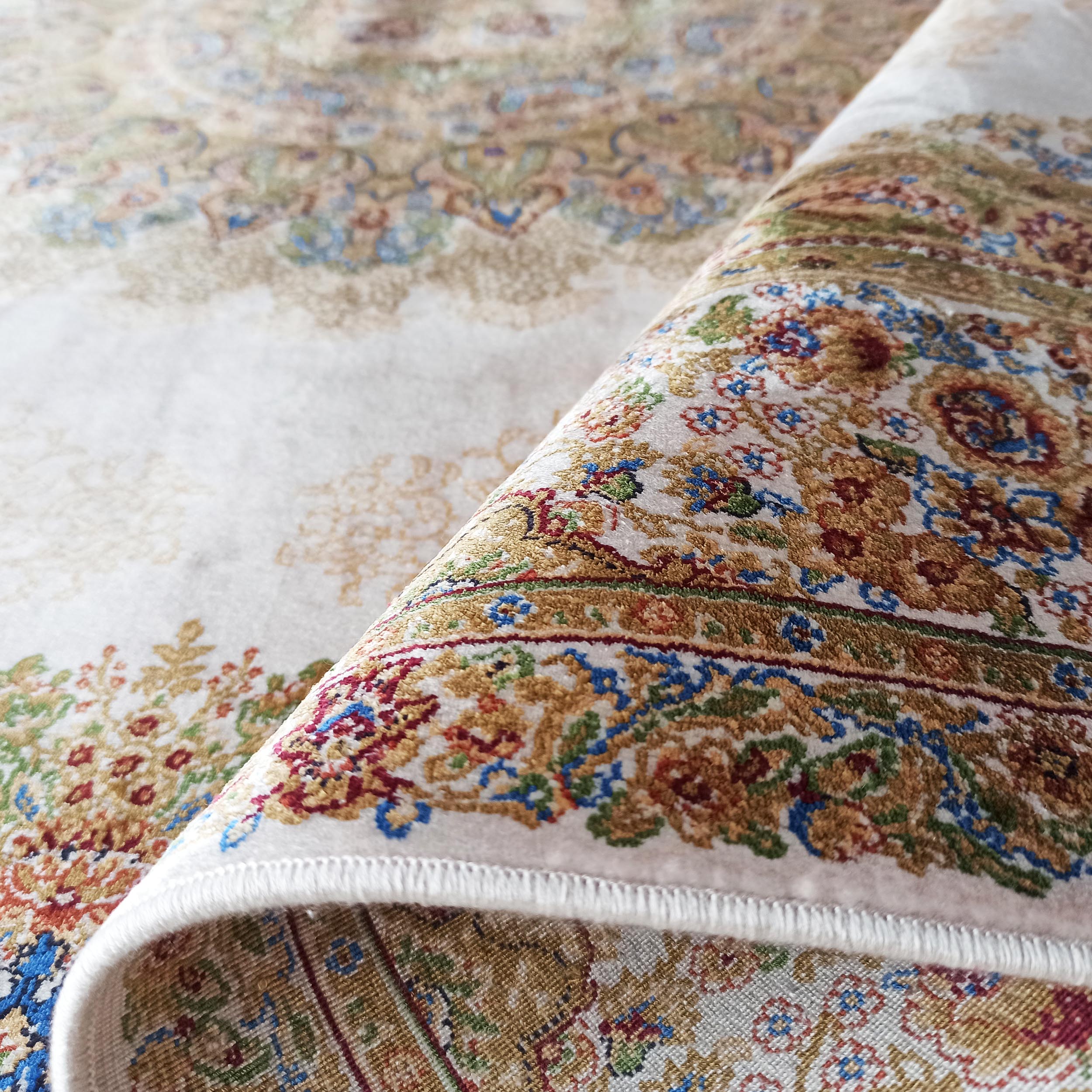 Tapis clair enroulé, à motifs floraux et ornementaux beige, or, rouge et bleu, avec une texture douce