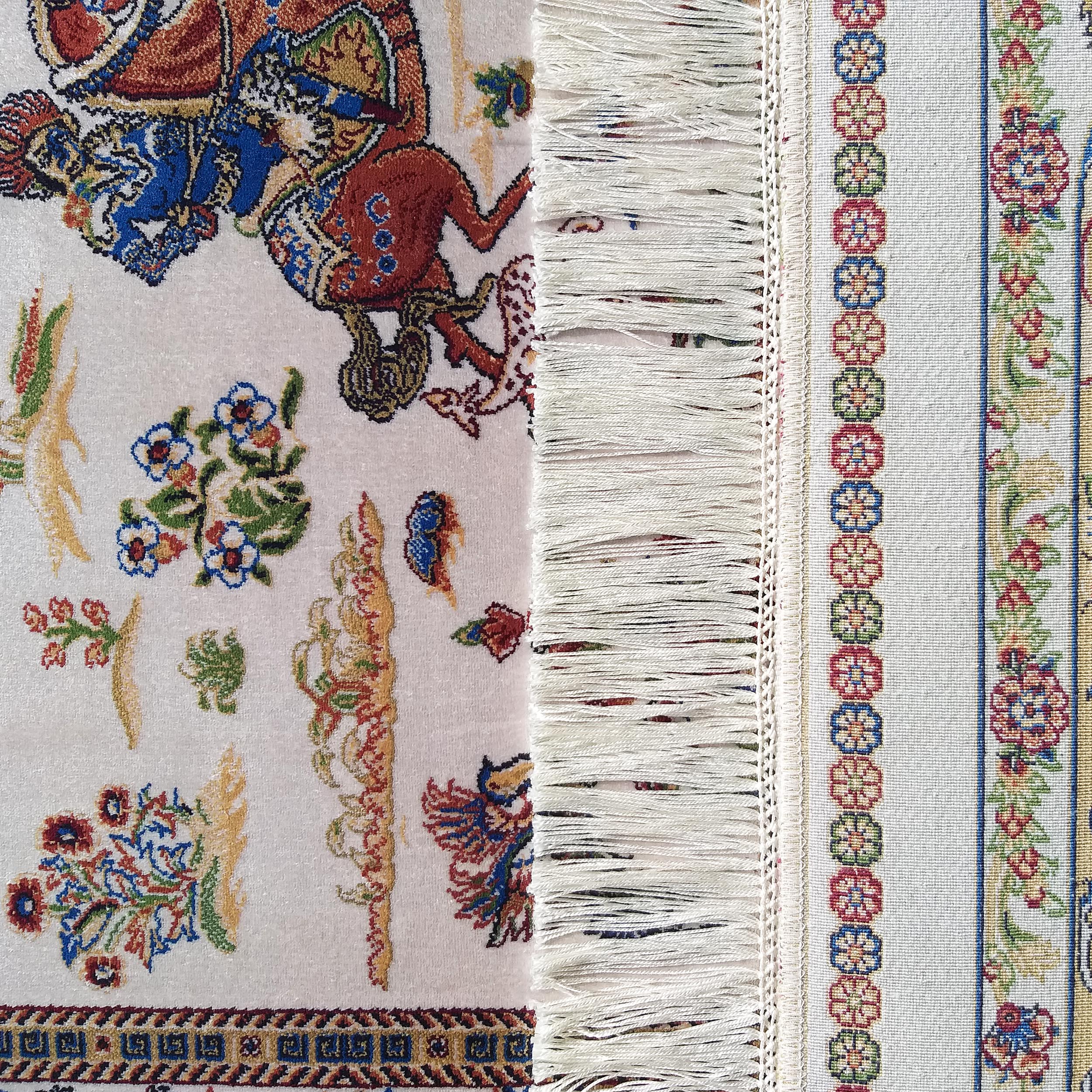 Tapis doux à motifs figuratifs et floraux complexes aux couleurs vives sur fond clair, franges et bordure tissée à fleurs