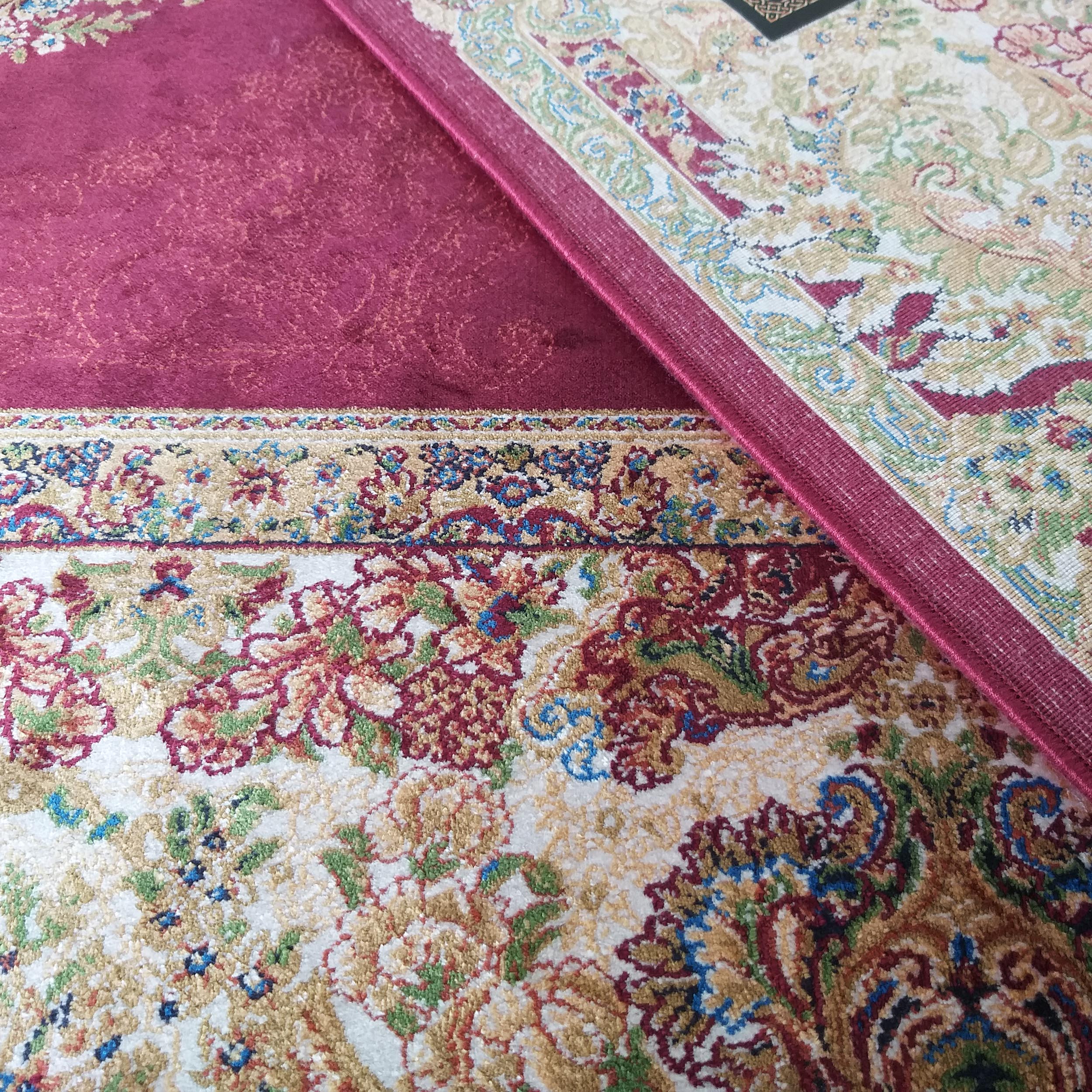 Tapis composé d'une section bordeaux à motif subtil et d'une section à motifs floraux orientaux multicolores