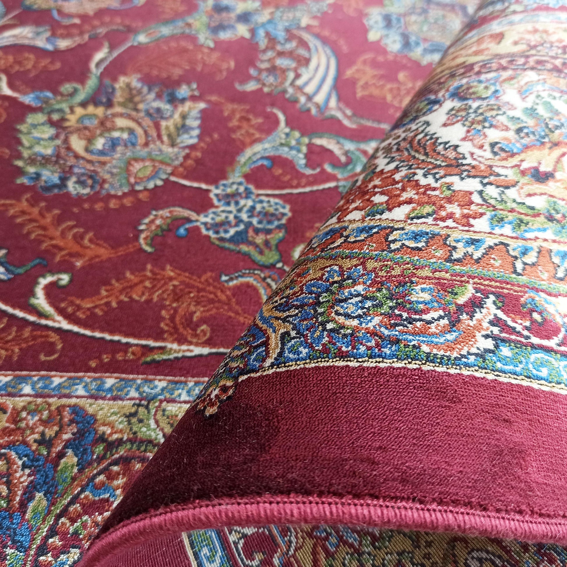 Tapis roulé rouge bordeaux à motifs ornementaux multicolores de texture douce