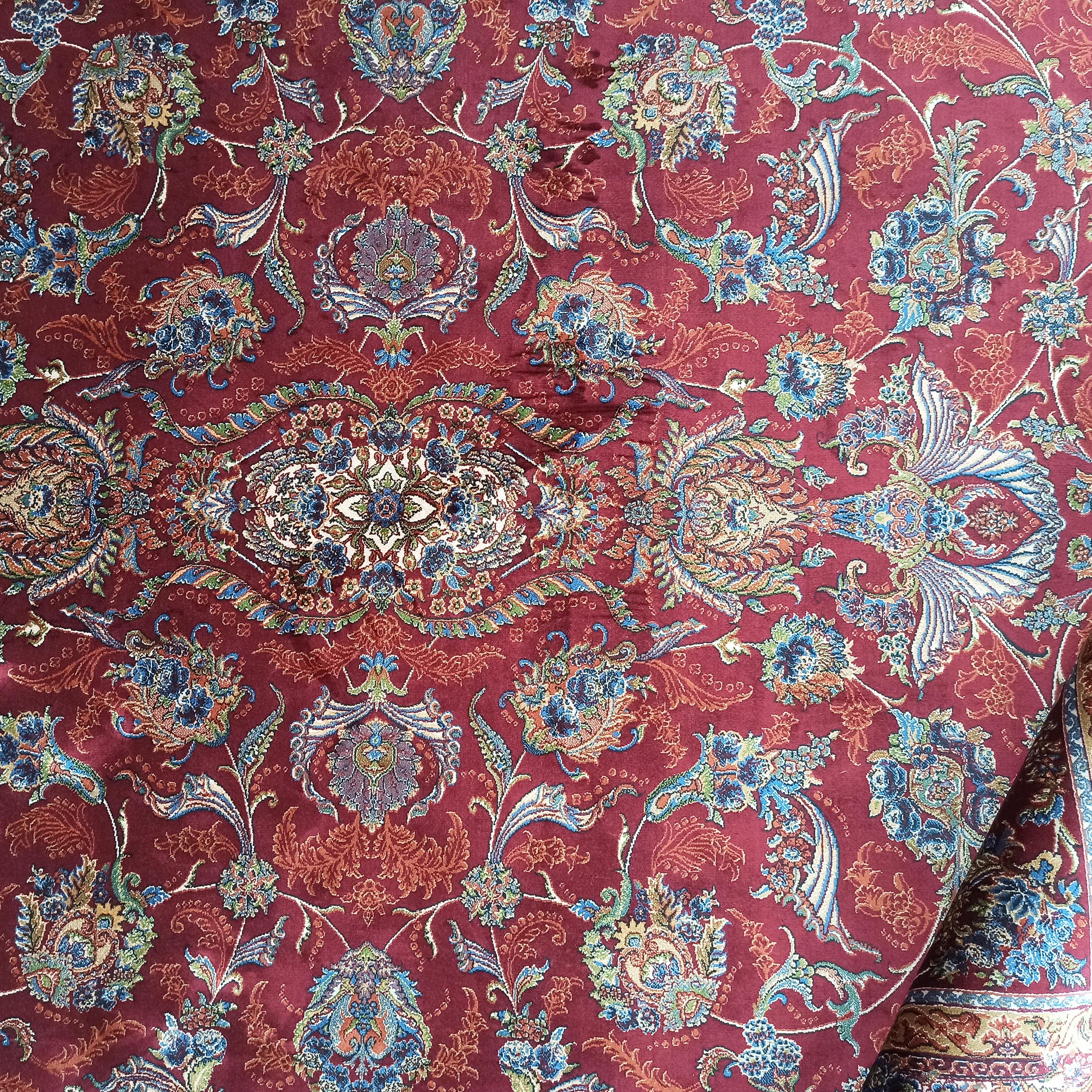 Tapis rouge bordeaux avec un motif floral traditionnel multicolore et un médaillon central richement détaillé