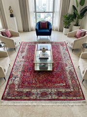 Grand tapis persan rectangulaire rouge grenat aux motifs floraux et animaux, bordure claire, dans un salon lumineux