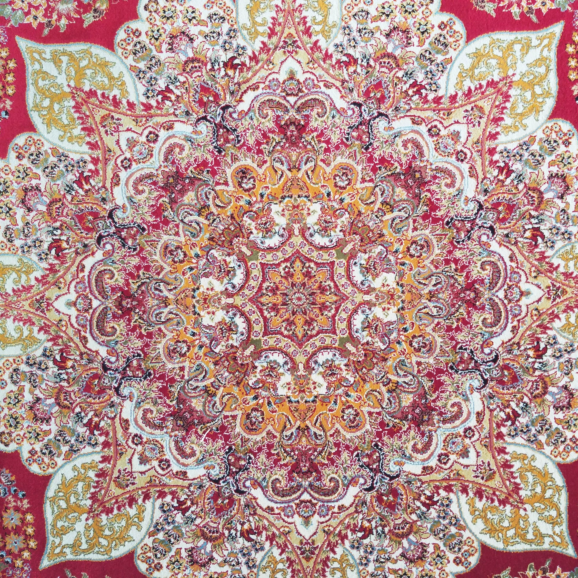 Tapis orné de motifs floraux entrelacés, dominé par un centre crème et des arabesques rouges, or et bleues