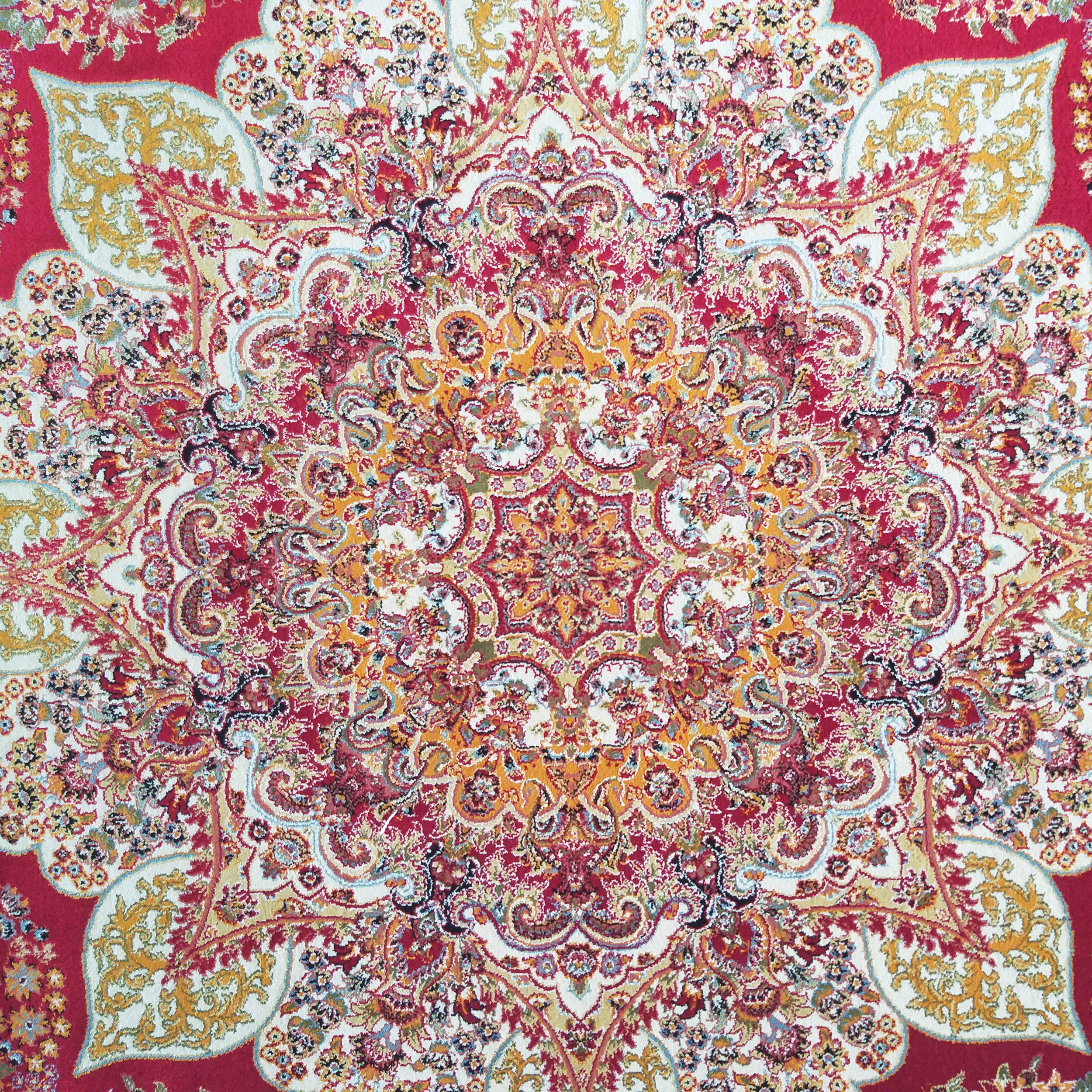 Tapis orné de motifs floraux entrelacés, dominé par un centre crème et des arabesques rouges, or et bleues