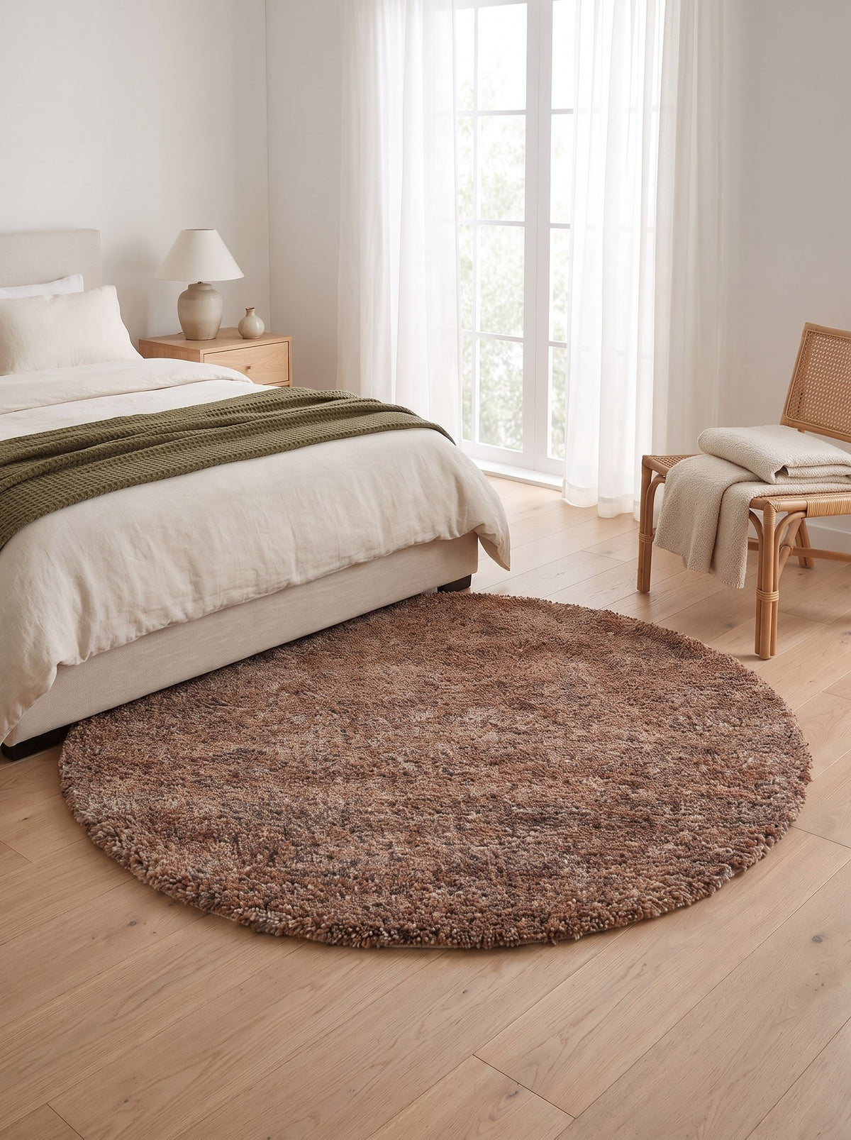 Wollteppich rund Terrakotta - Folto neben dem Bett im Schlafzimmer einer hellen Neubauwohnung, auf hellem Eichenparkett