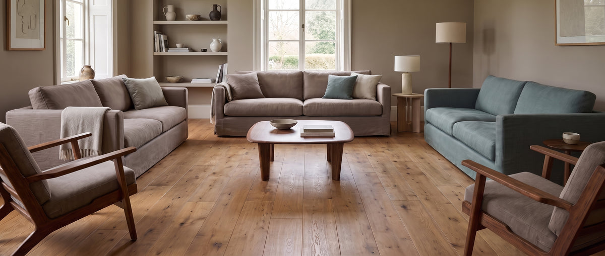 Un salon lumineux et chaleureux au parquet en bois, sans tapis, meublé de canapés douillets