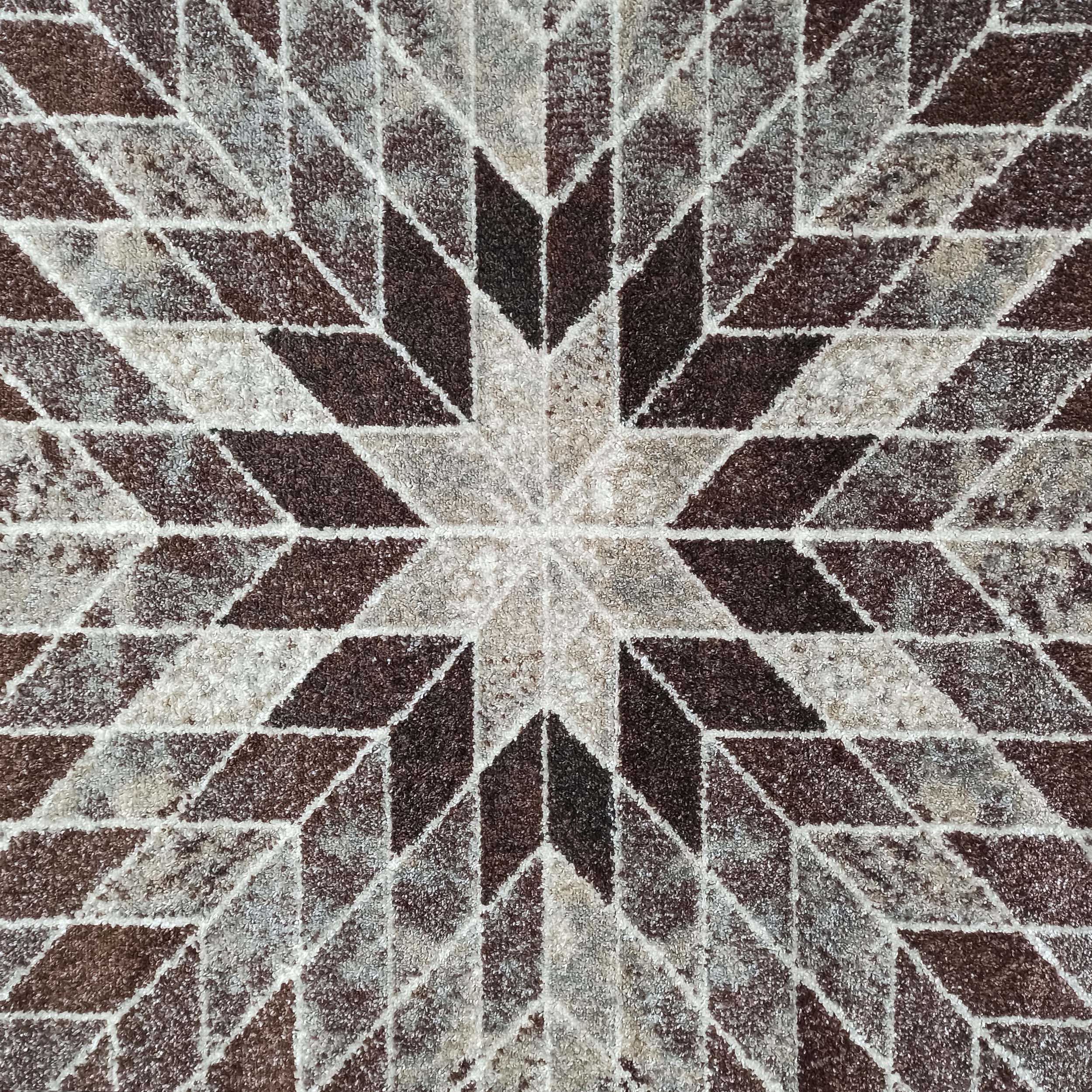 Tapis à motif géométrique étoilé en losanges et triangles, aux couleurs variées de marron, gris, beige et blanc cassé