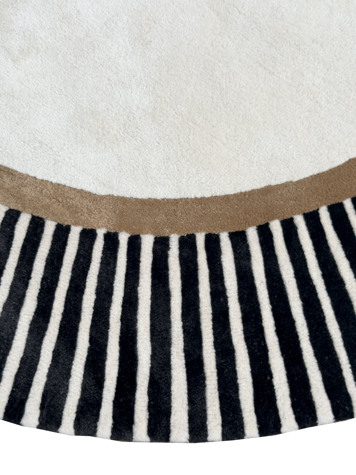 Le relief des fibres de laine et viscose met en valeur les motifs ivoire, l'anneau marron et les rayures noires