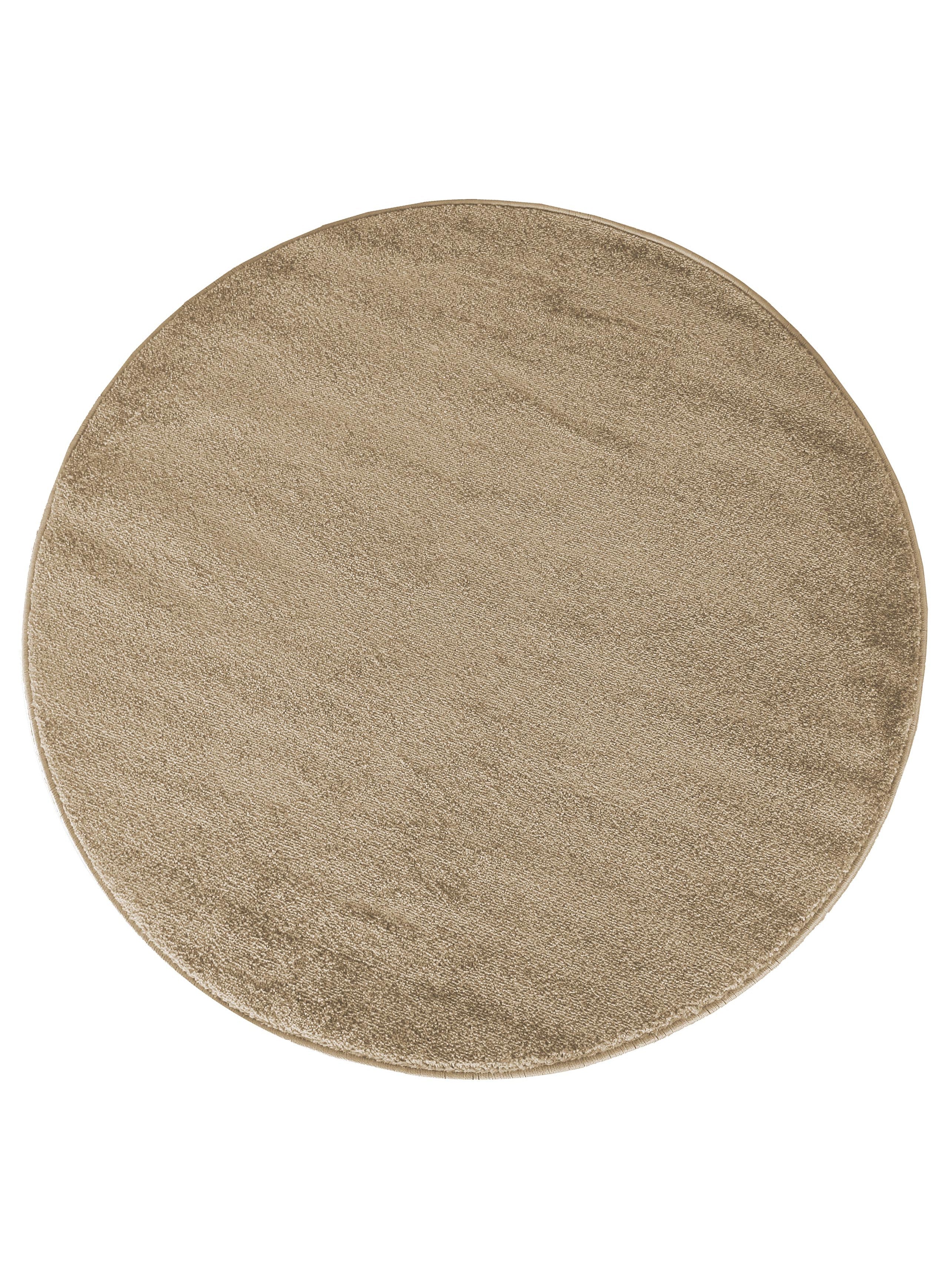 Tapis rond beige à la surface texturée et moelleuse, avec des variations de lumière donnant des nuances subtiles