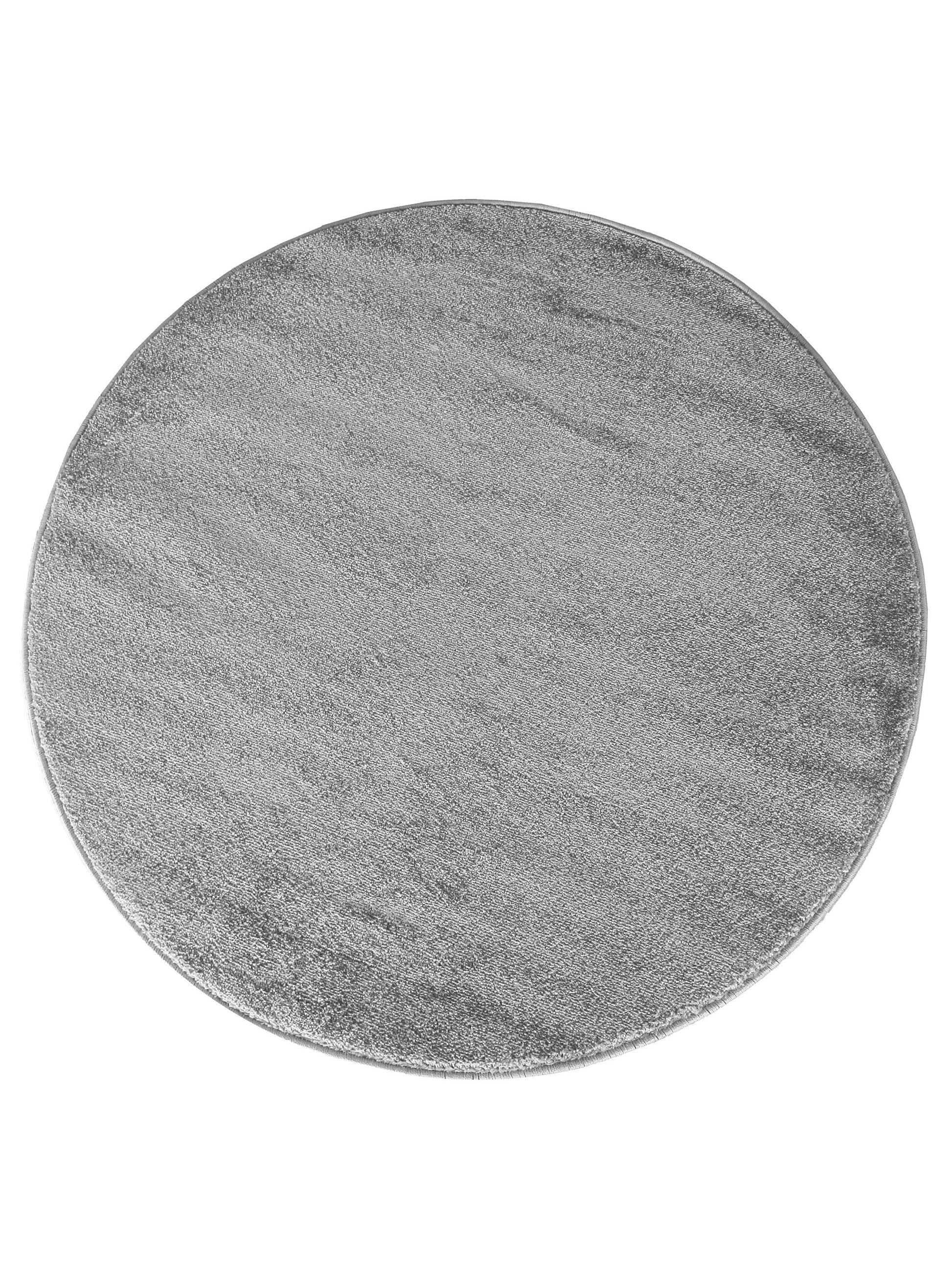 Tapis ovale gris clair à la texture douce et aux poils courts, présentant des nuances subtiles sur un fond blanc uni