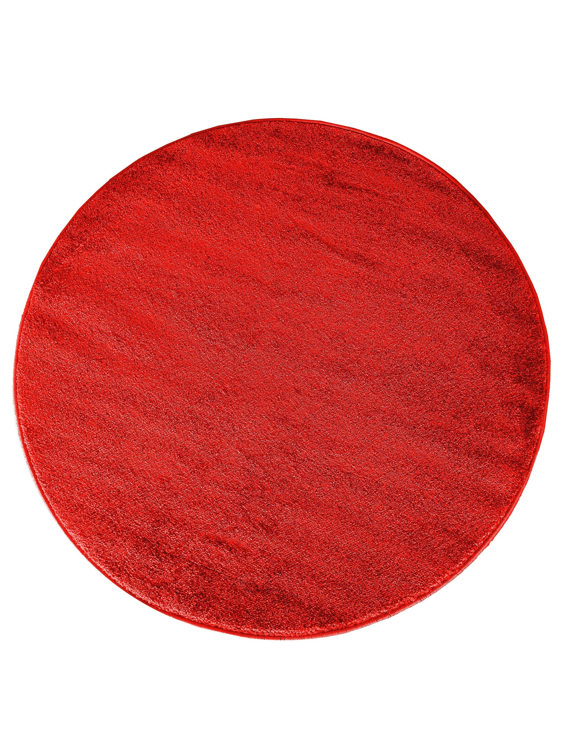Tapis ovale d'un rouge écarlate profond, à la surface textile unie et douce reflétant subtilement la lumière