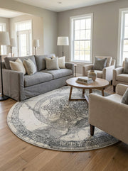 Tapis rond crème à motifs gris foncés de style médaillon et géométrique, posé sur un parquet dans un salon moderne et lumineux