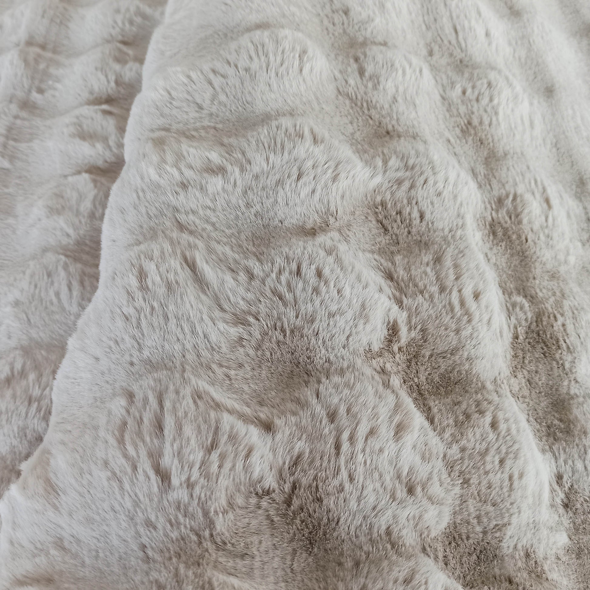 Tapis moelleux à poils longs de couleur beige clair et blanc cassé, avec une texture douce ressemblant à de la fourrure
