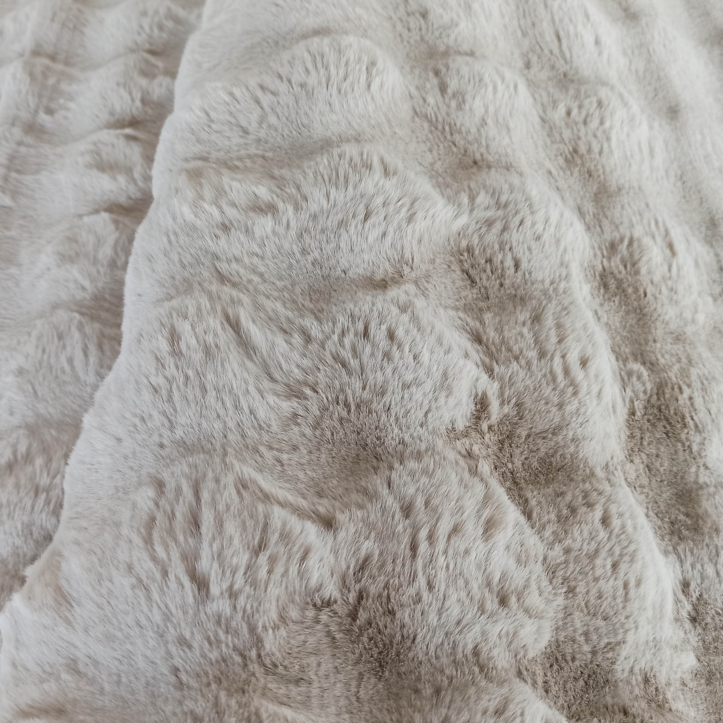 Tapis moelleux à poils longs de couleur beige clair et blanc cassé, avec une texture douce ressemblant à de la fourrure