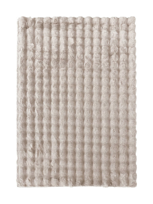 Tapis rectangulaire beige clair texturé avec des motifs ronds en relief, donnant une impression de douceur moelleuse