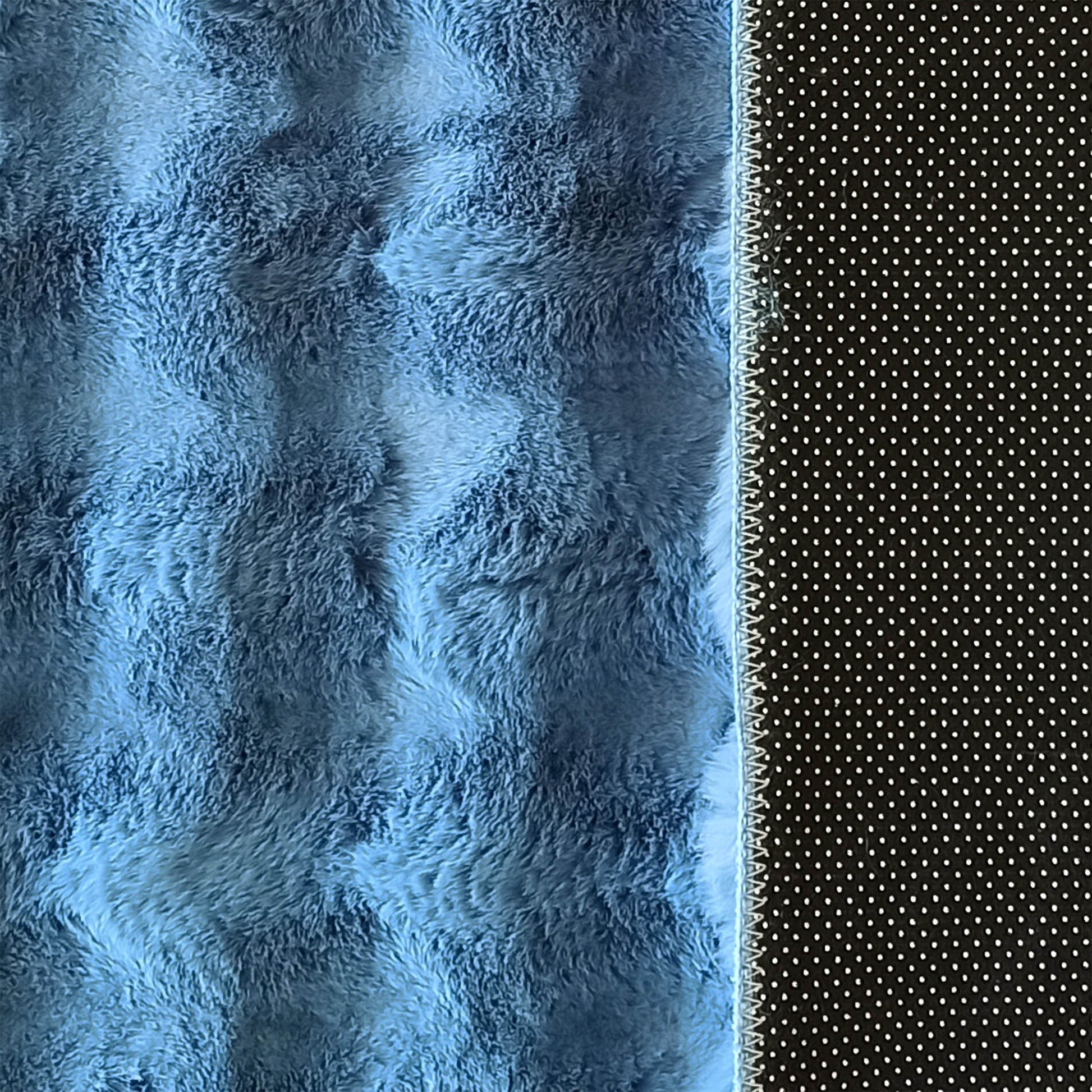 Tapis doux bleu à longue texture fourrure avec une bordure cousue et un côté noir à petits pois blancs
