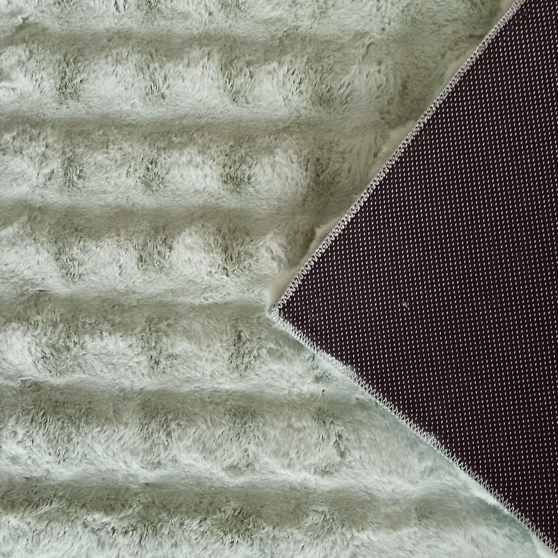 Tapis doux à poils longs vert menthe avec un motif en côtes et un revers antidérapant noir à petits points blancs visible