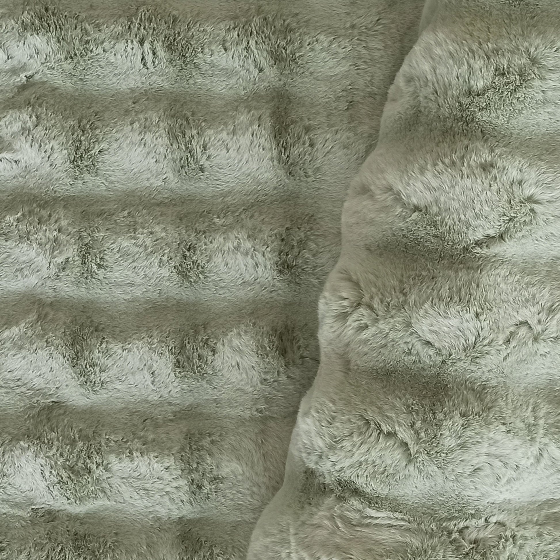 Tapis vert-gris clair à poils longs. Sa surface présente des bandes horizontales en relief et une zone plus ébouriffée