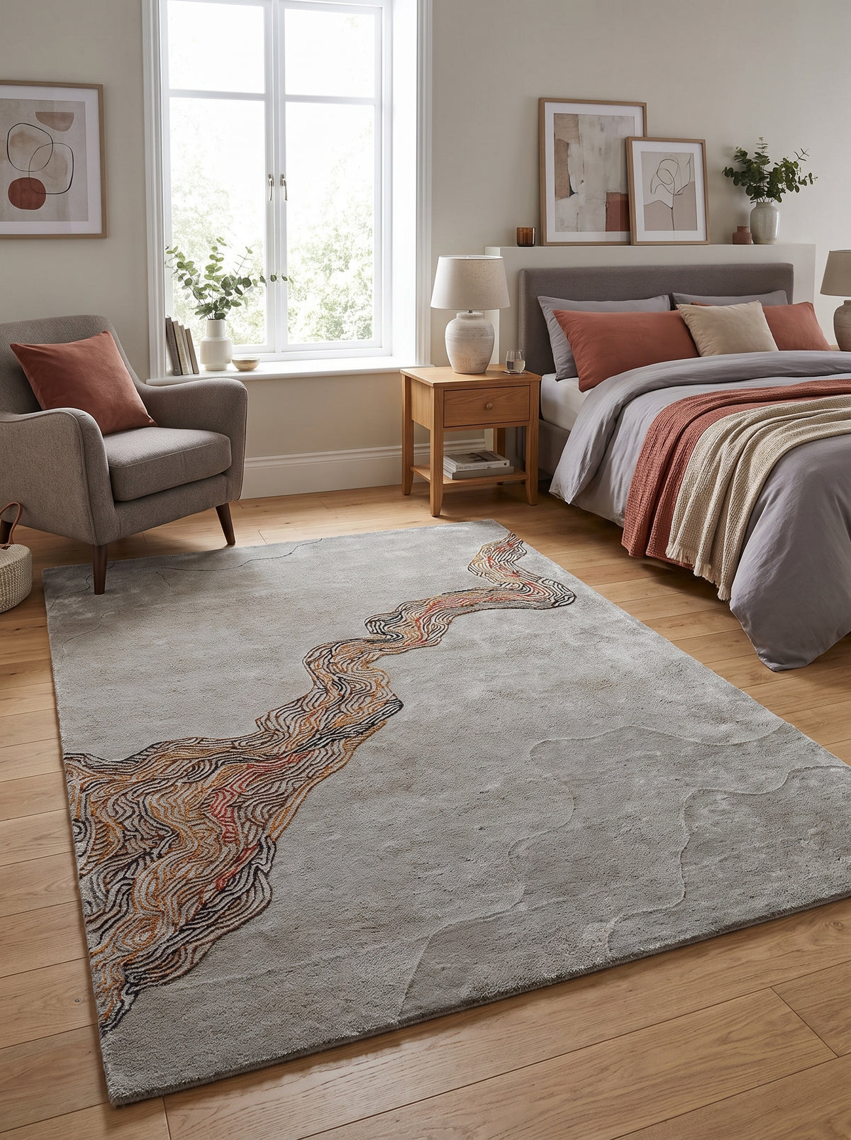 Un tapis fait main en tencel et laine gris et terracotta, aux motifs ondulants dans une chambre lumineuse