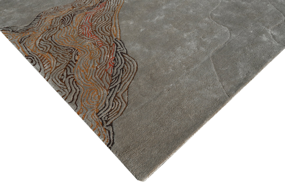 La texture du tapis en tencel et laine gris et terracotta, avec ses motifs abstraits et son relief marqué, apparaît en détail