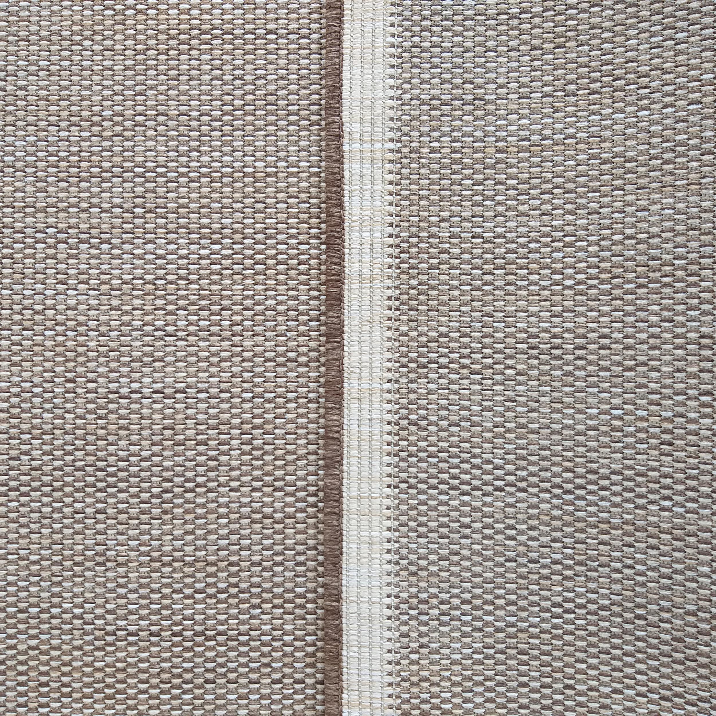 Tapis texturé aux tons de beige et marron, traversé par une bande centrale verticale contrastée de brun foncé et crème