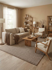 Tapis rectangulaire tissé marron et beige avec un motif chiné subtil, posé sur un plancher clair dans un salon