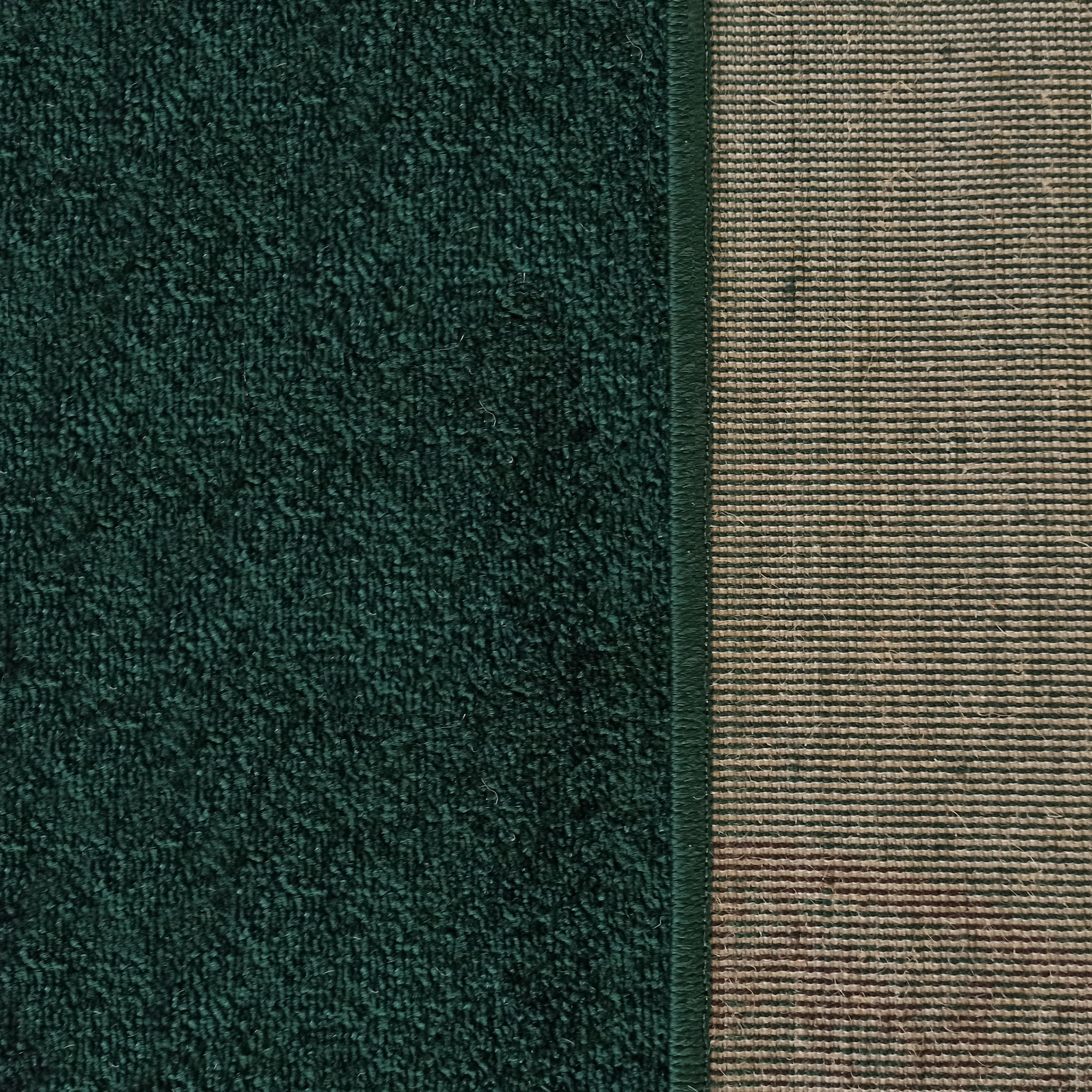 Tapis vert émeraude à la surface douce et bouclée, avec son revers tissé beige et vert aux motifs rayés horizontaux