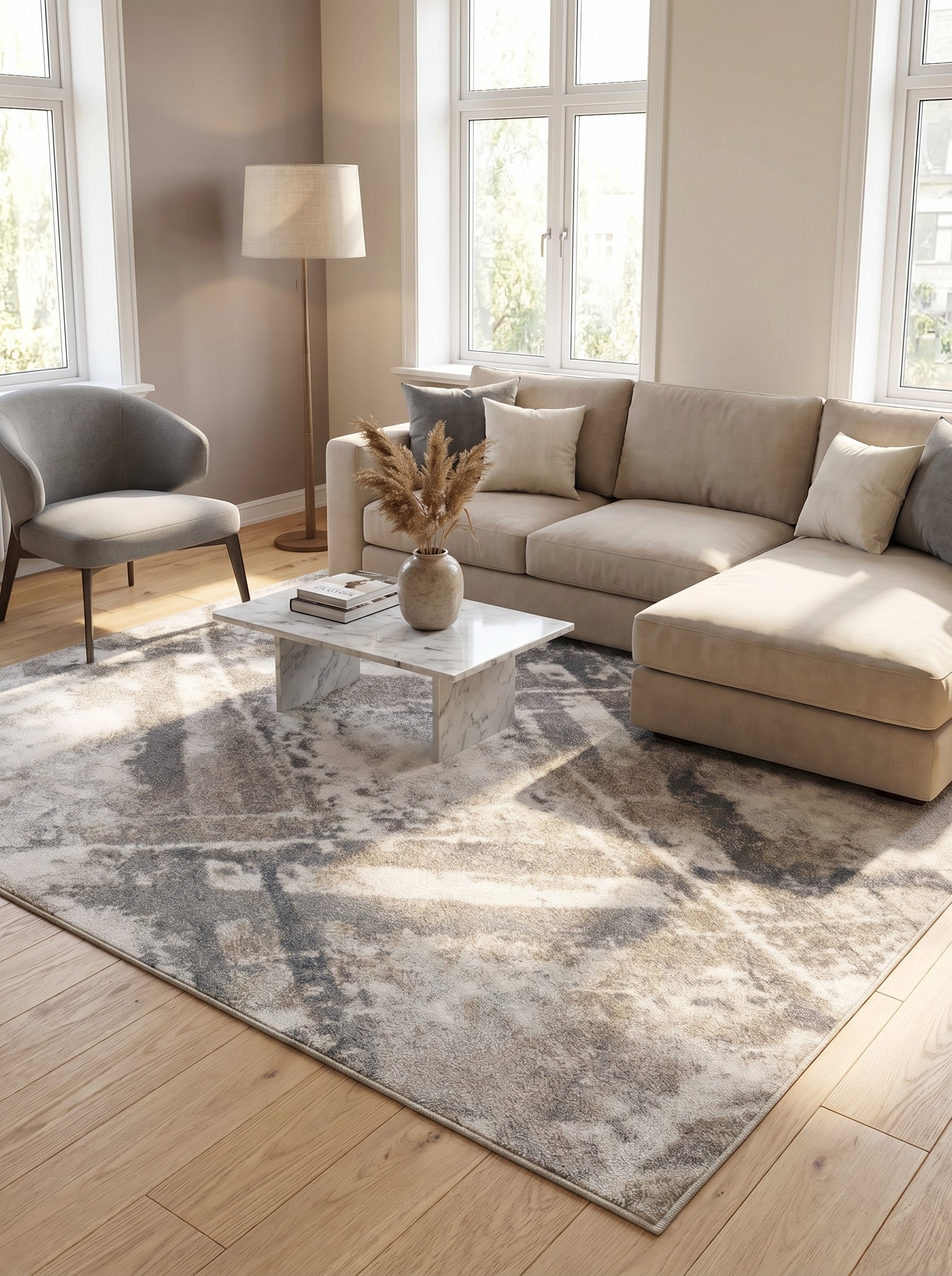 Tapis rectangulaire aux motifs abstraits et délavés de gris, beige et crème, posé sur le sol d'un salon moderne