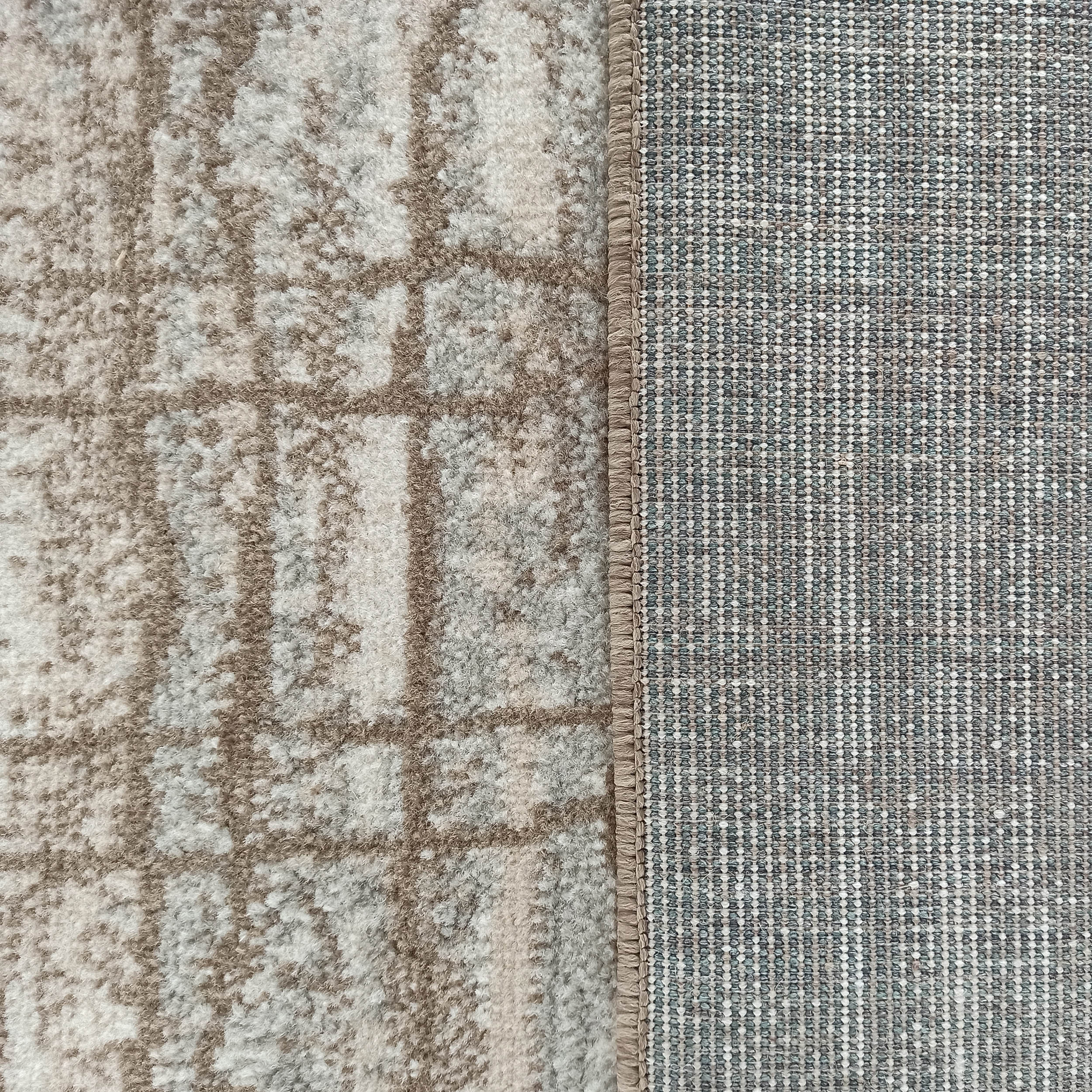Tapis à poils longs beige et marron à motif abstrait, avec son dos tissé gris moucheté et sa bordure cousue
