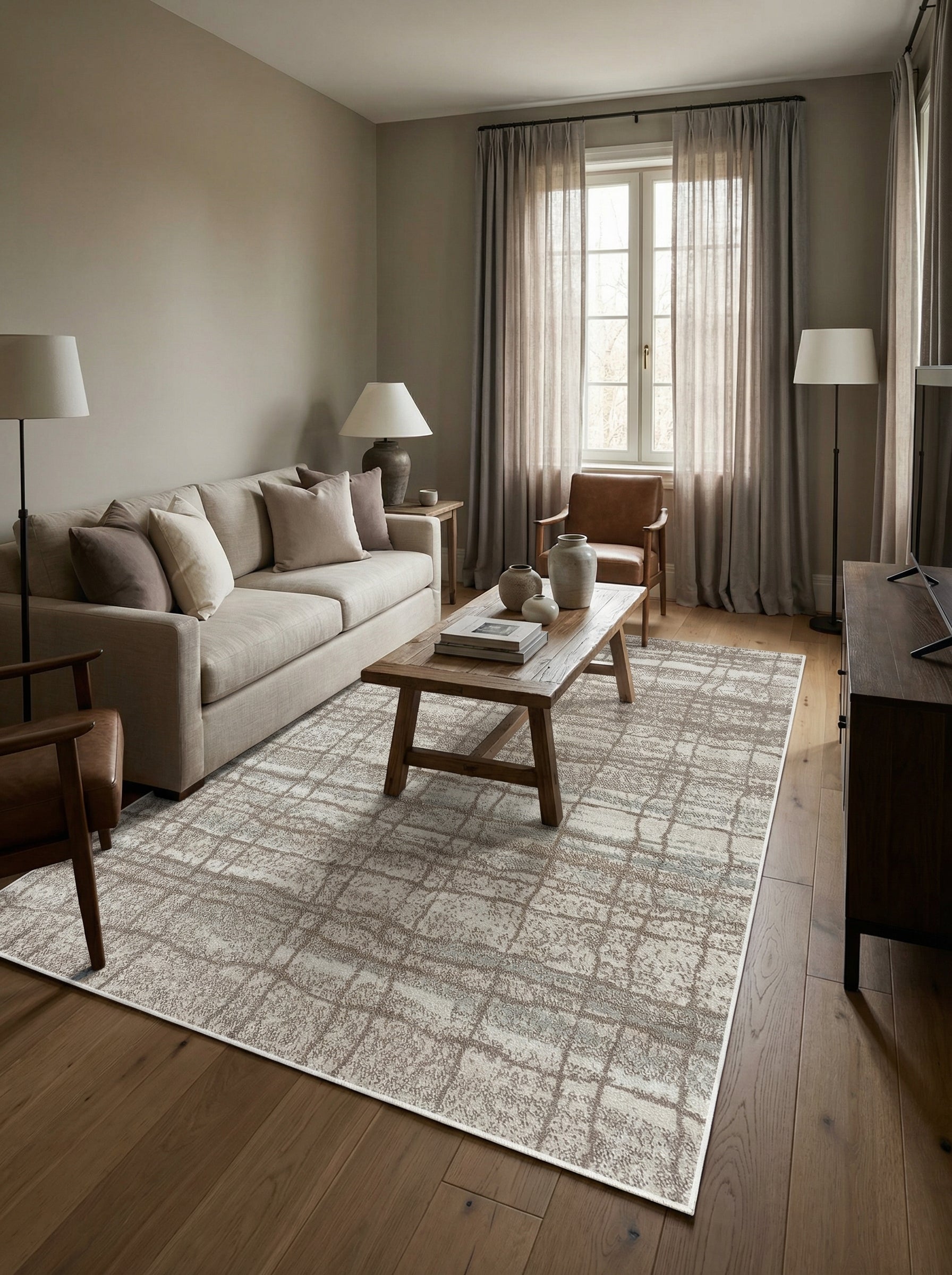 Tapis rectangulaire beige clair avec un motif géométrique abstrait marron et texturé, posé sur un parquet dans un salon