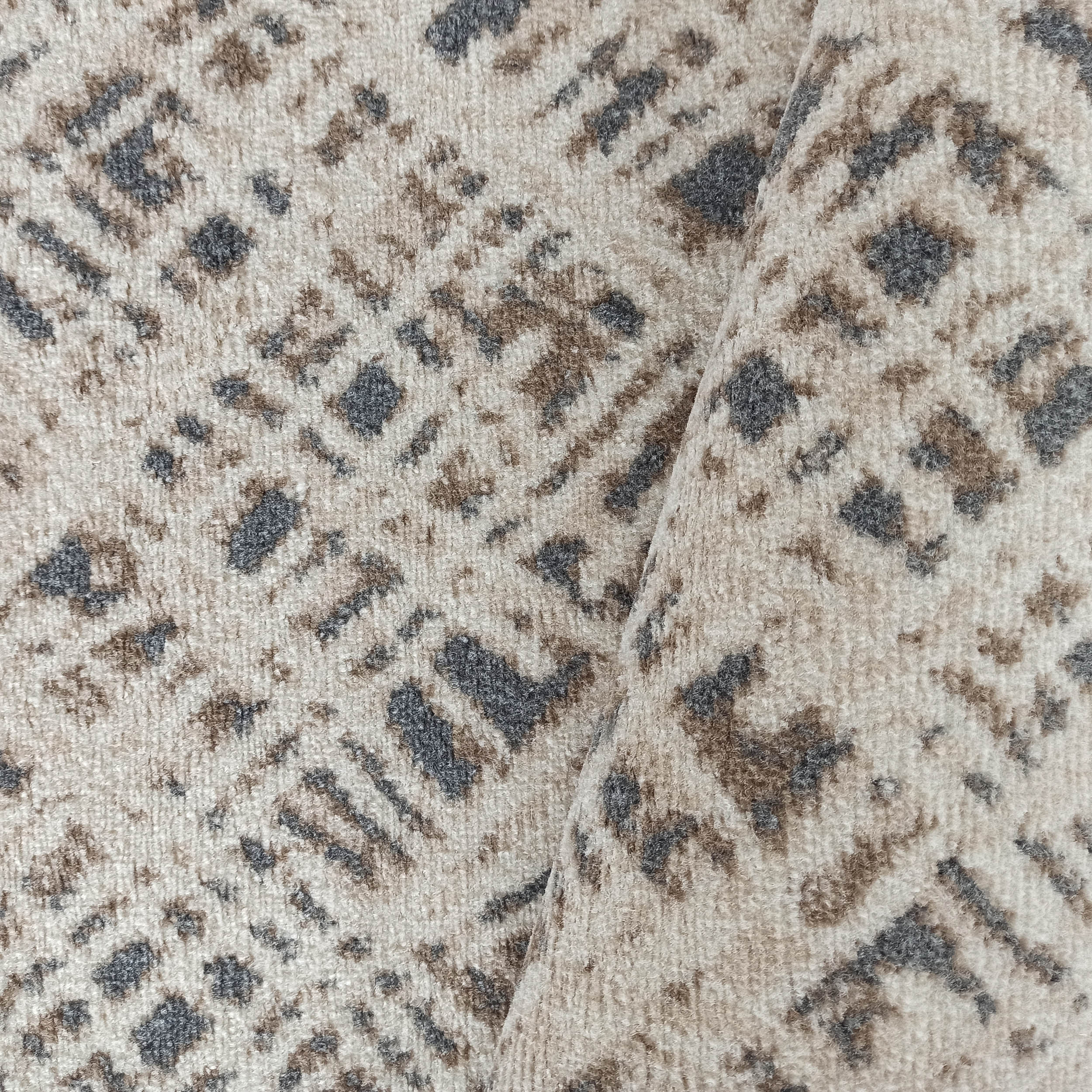 Tapis à poils courts beige clair avec des motifs irréguliers gris foncé et bruns