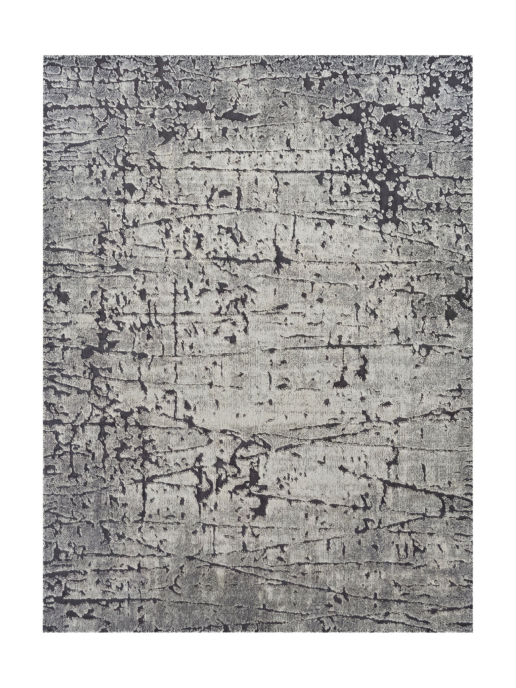 Tapis rectangulaire aux teintes de gris claires et foncées, avec un motif abstrait texturé de craquelures