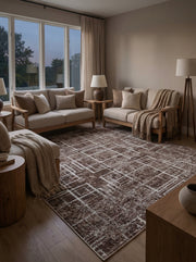Tapis rectangulaire marron foncé à motifs géométriques abstraits crème, posé sur le sol d'un salon moderne