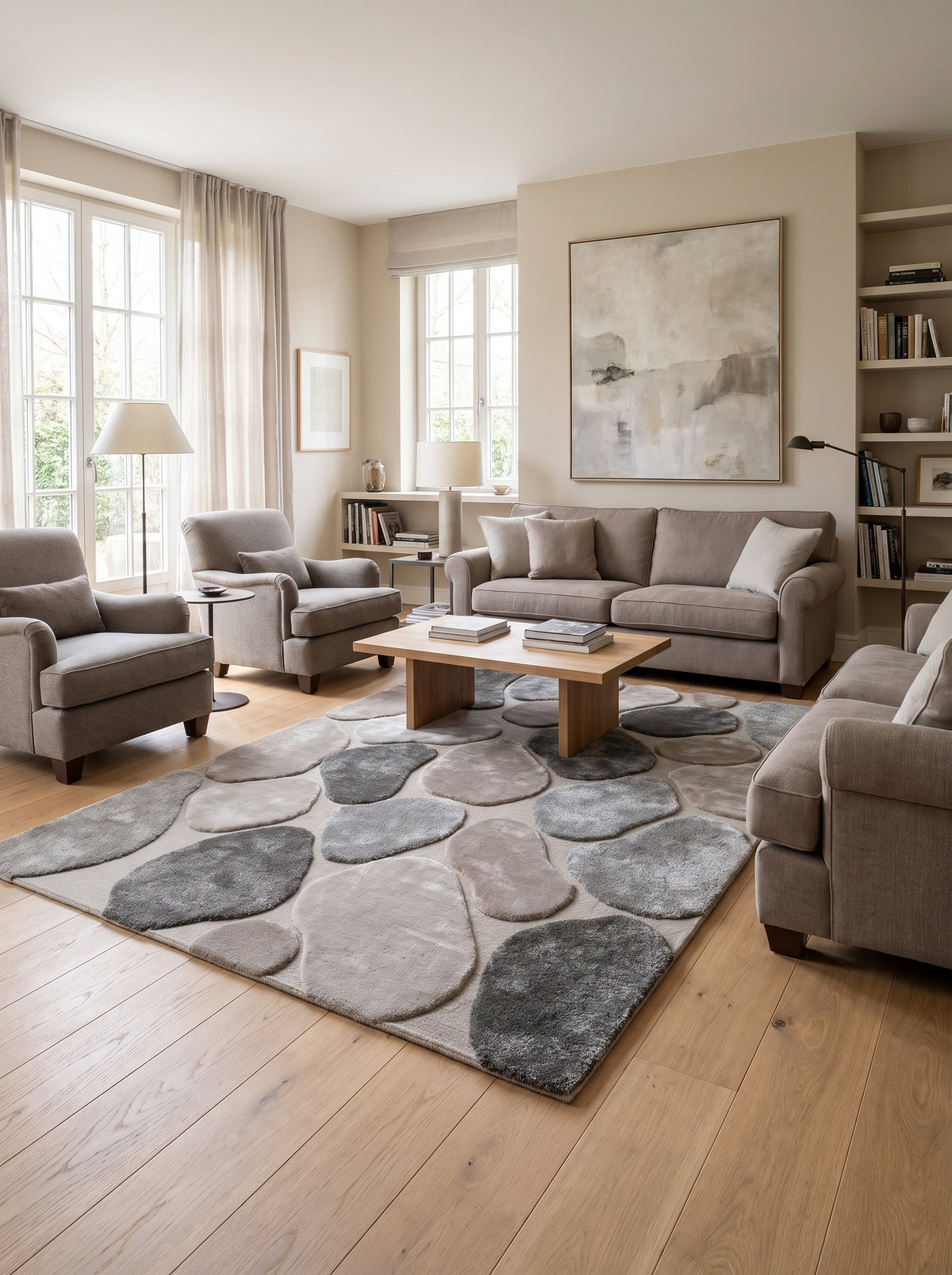 Gris, charbon et taupe animent les galets en laine et viscose de ce tapis rectangulaire, posé dans un salon
